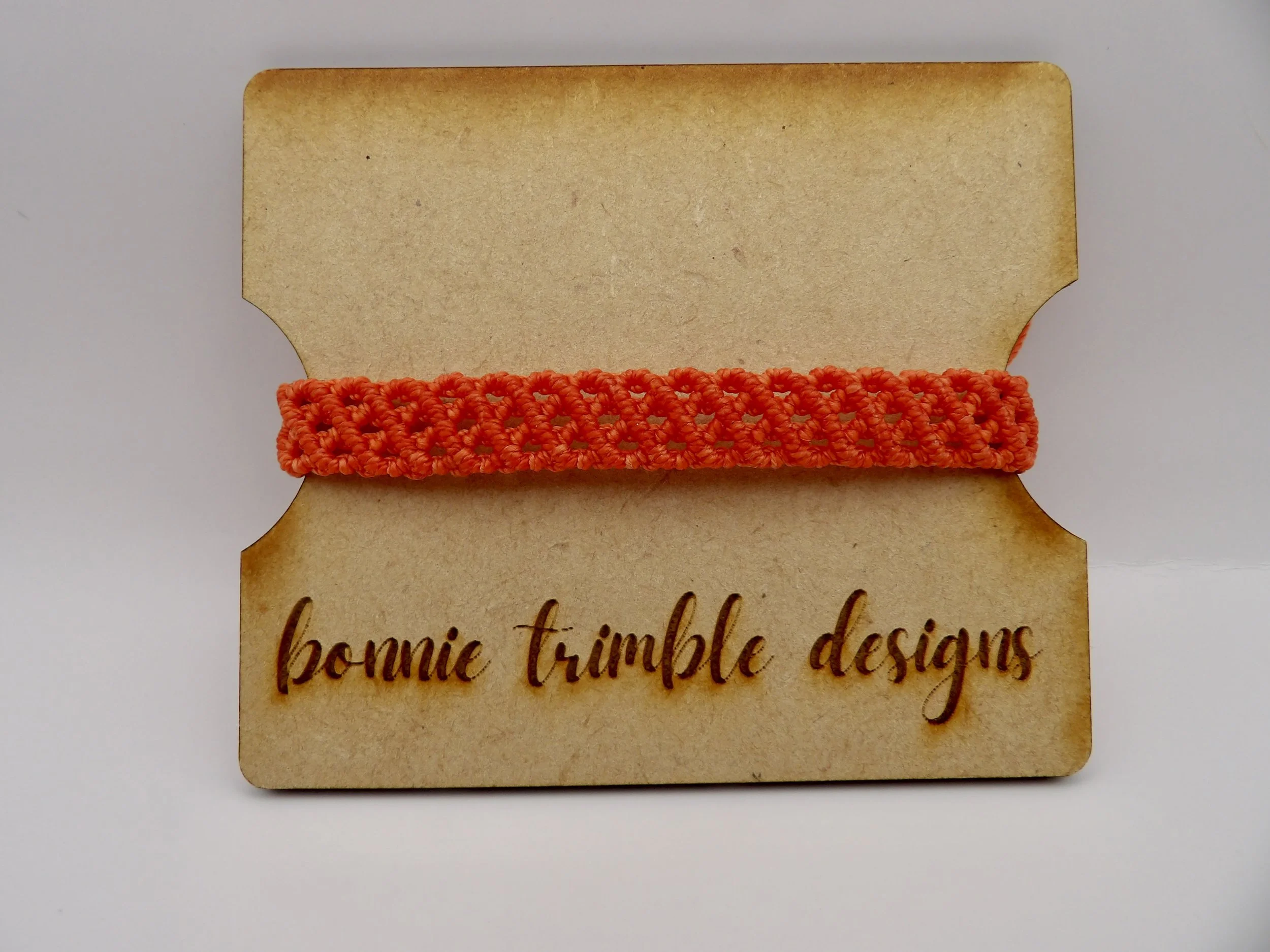 handmade dark orange micro macrame bracelet designed to look like a 3-piece stack, with a single stainless steel lobster clasp.