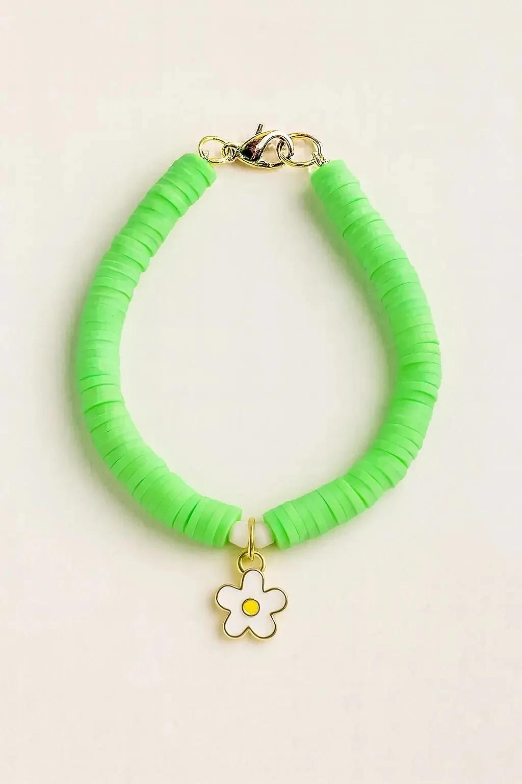 the sunny daisy bracelet featuring vibrant green clay heishi beads, shimmering crystal spacers, and a polished gold-finish daisy charm.