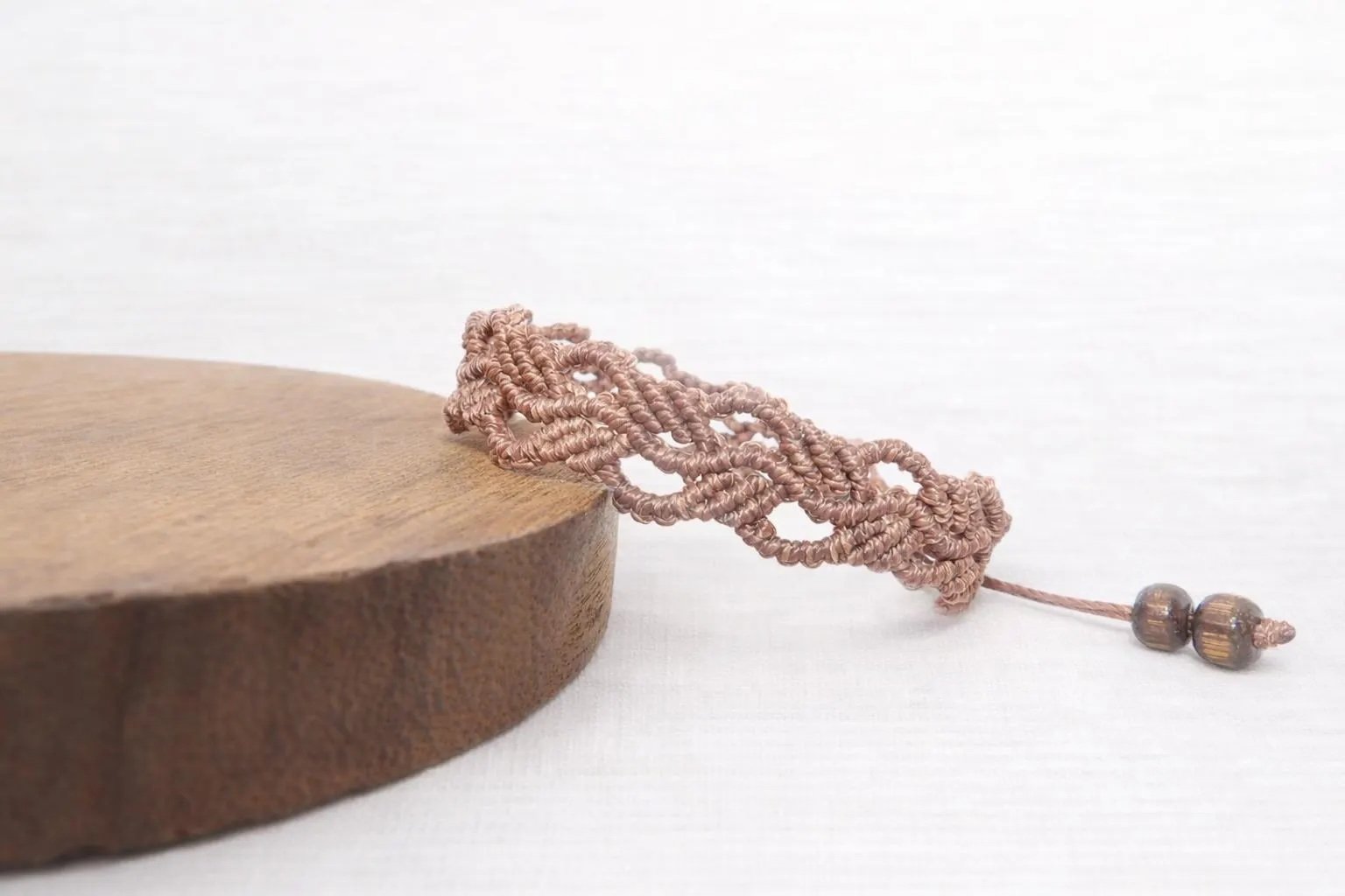 a highly detailed artisan bracelet showing the technical botanical weave and secure adjustable sliding knot closure.