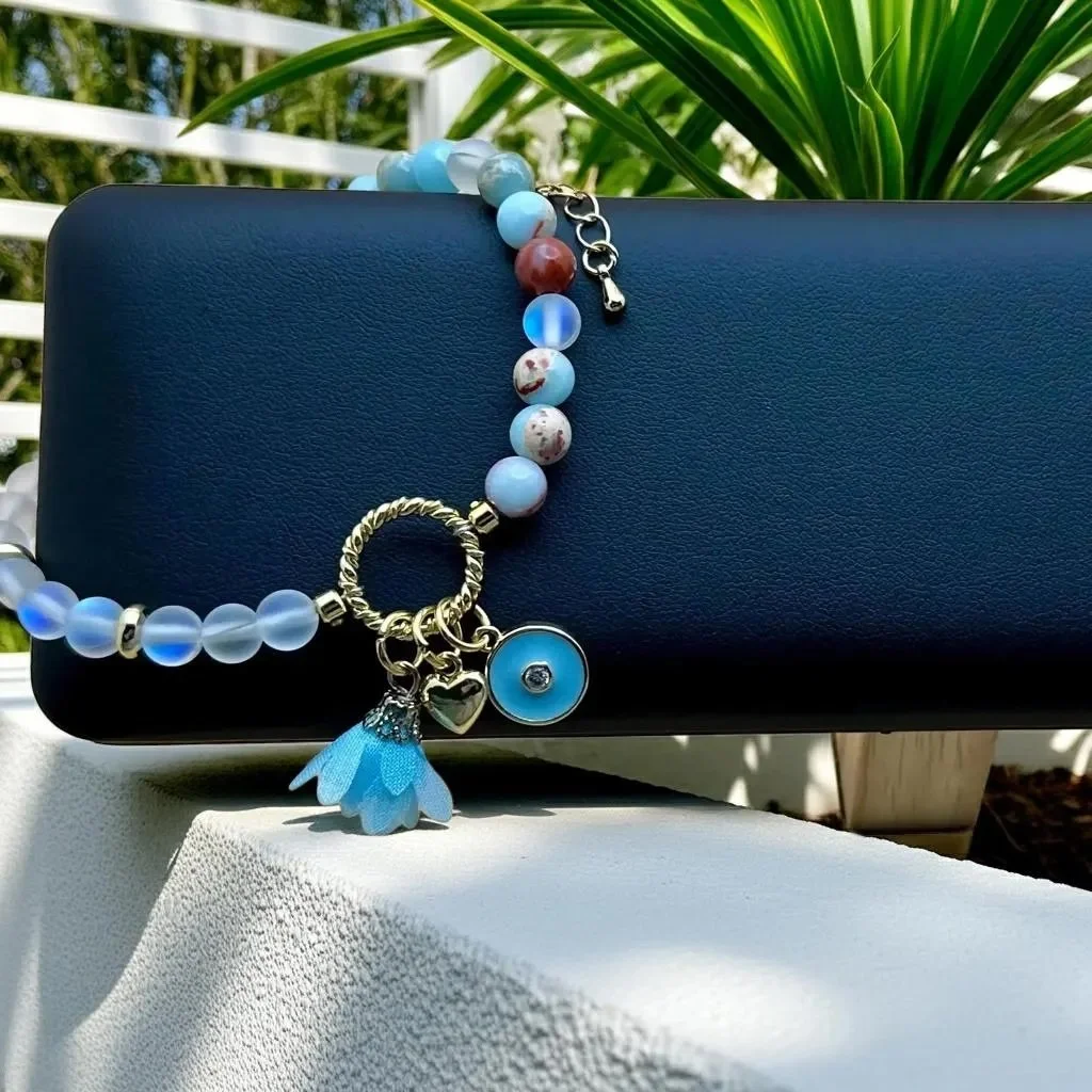 handcrafted 18k gold filled charm bracelet with a dainty cluster of blue and iridescent gemstones.