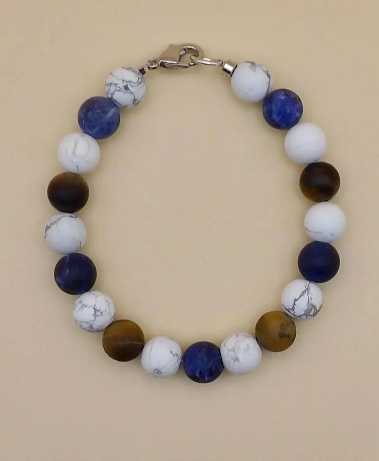 handcrafted men's wellness jewelry showing the matte texture of howlite beads paired with polished sodalite and tiger's eye.