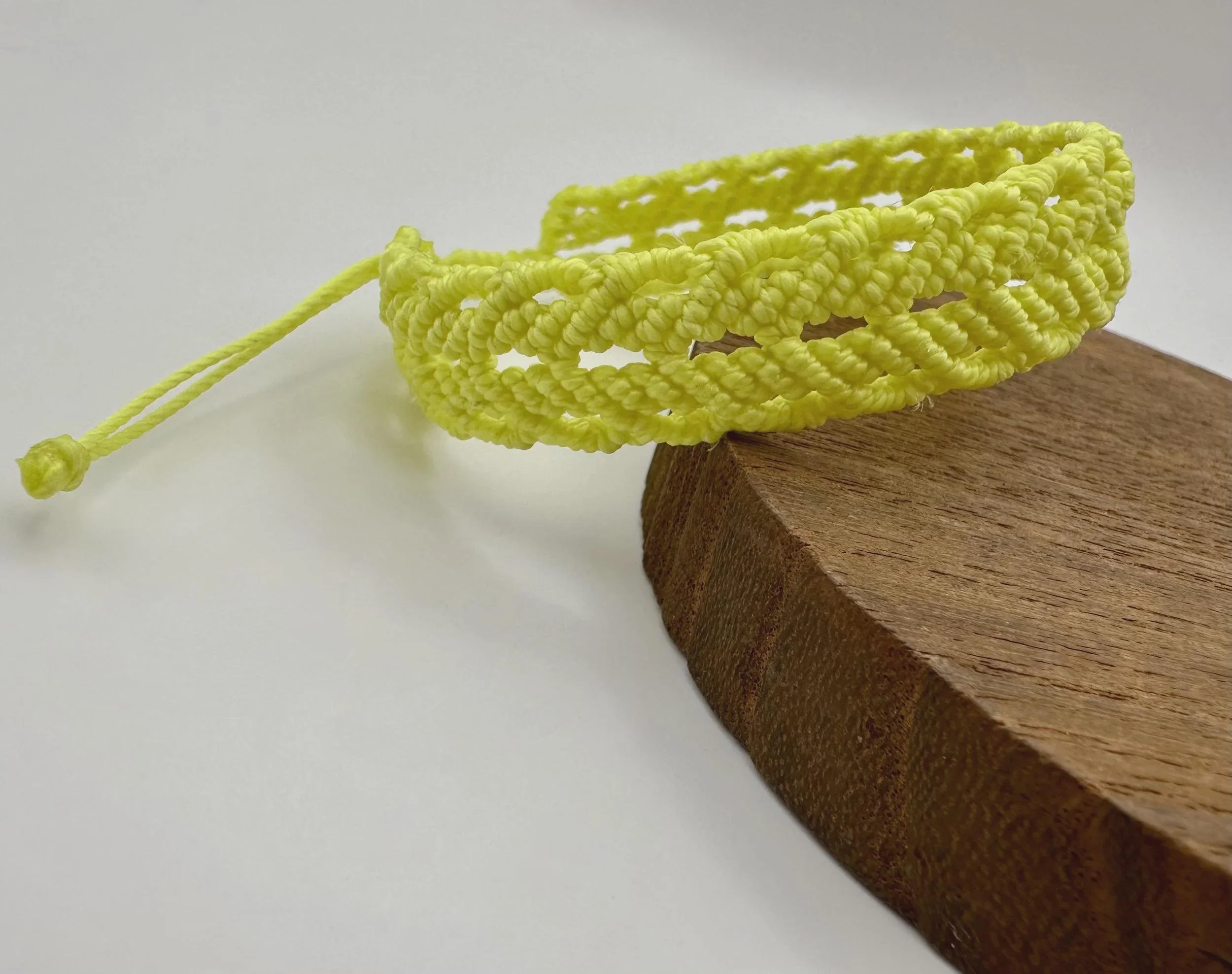 handcrafted micro-macramé jewelry designed for the 2026 "modern folk" aesthetic with signature etched wood tail beads.