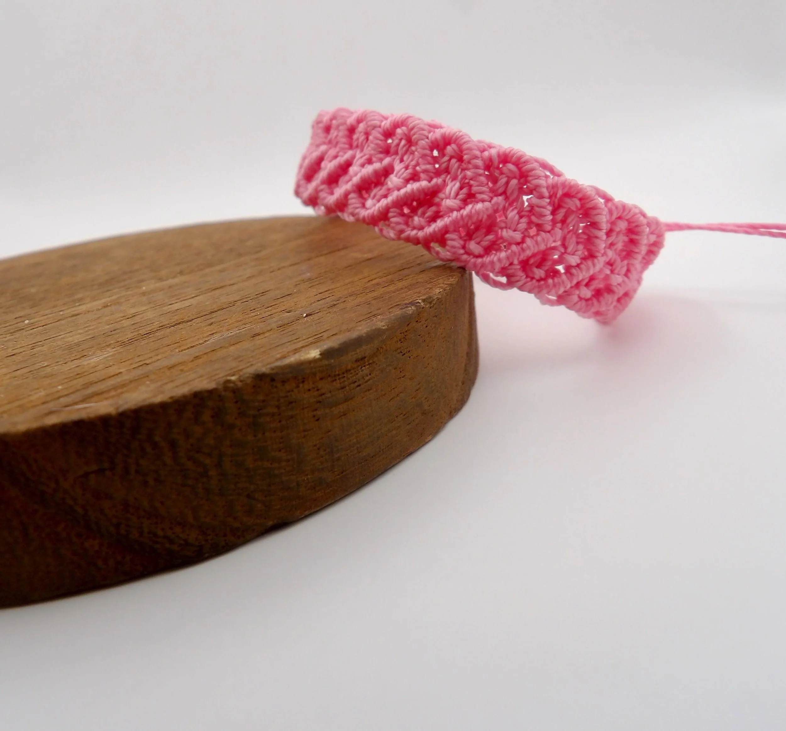 adjustable bohemian macramé cuff in a soft romantic color palette with a distinct woven heart focal point.