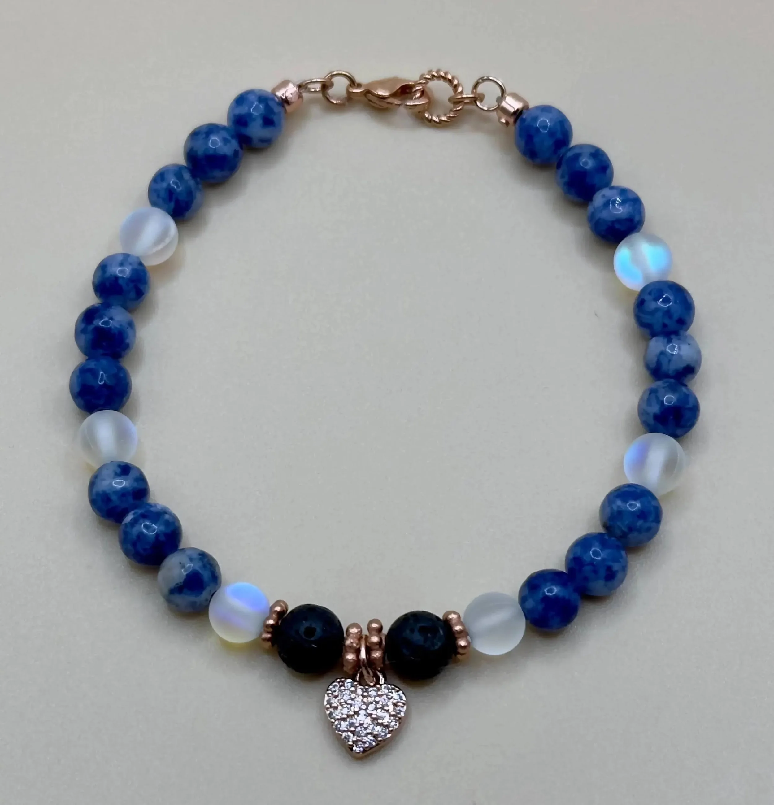 detailed view of the signature blue gemstone charms and the polished finish of the 18k gold-filled hardware.