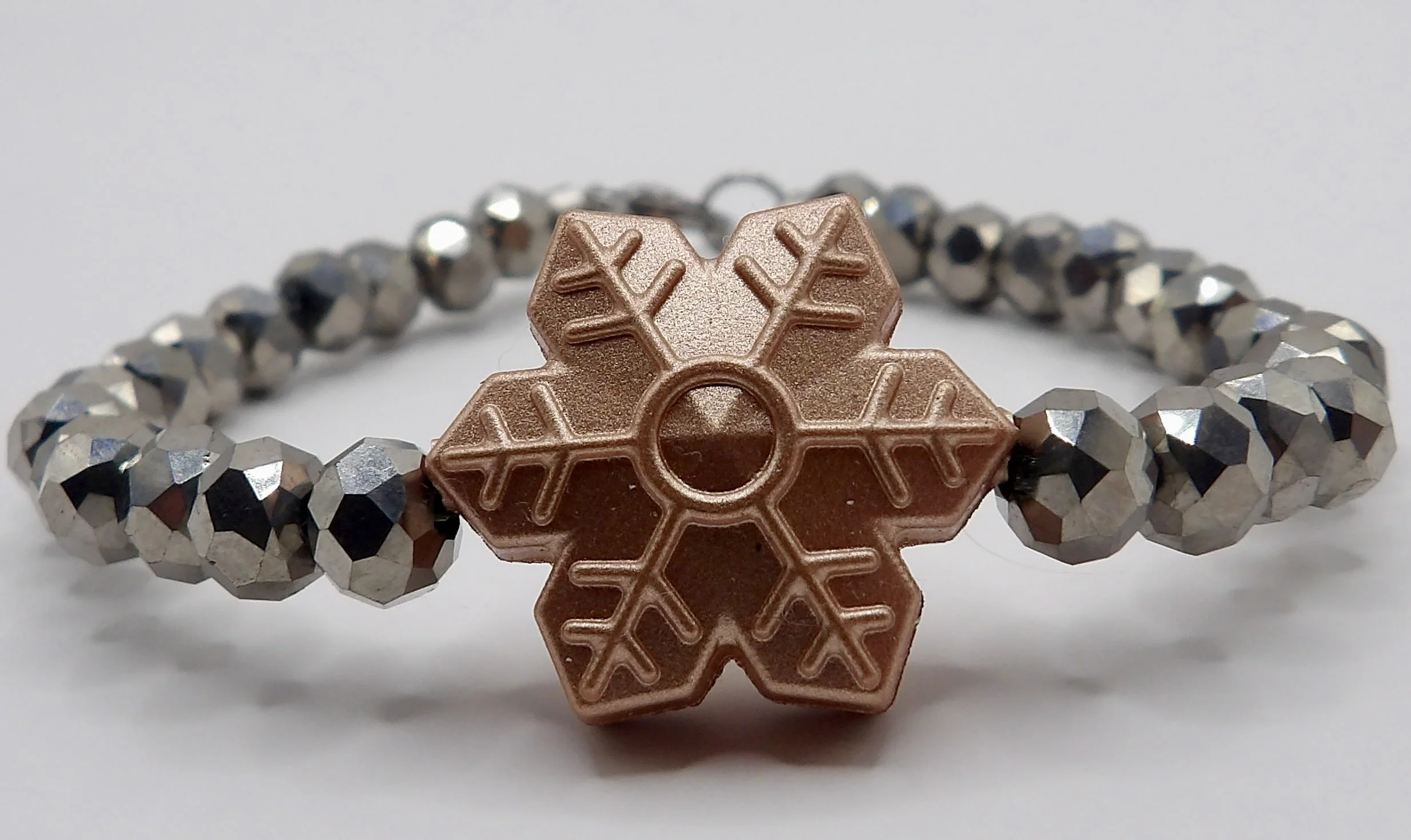 person wearing the dainty deep red glass bead snowflake bracelet, showing its festive holiday style.