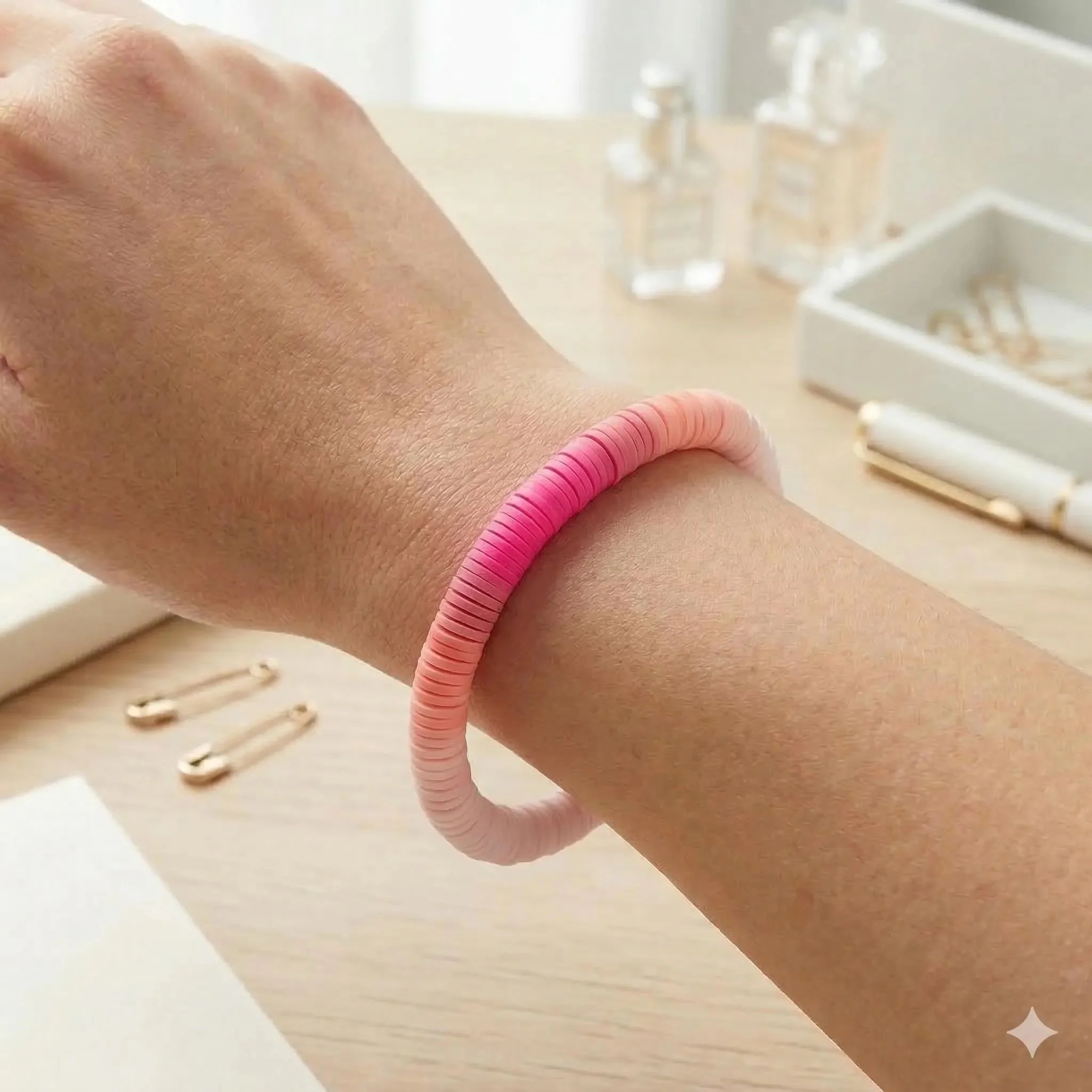 a modern heishi stacking bracelet showing a seamless transition from deep magenta to soft pastel pink.