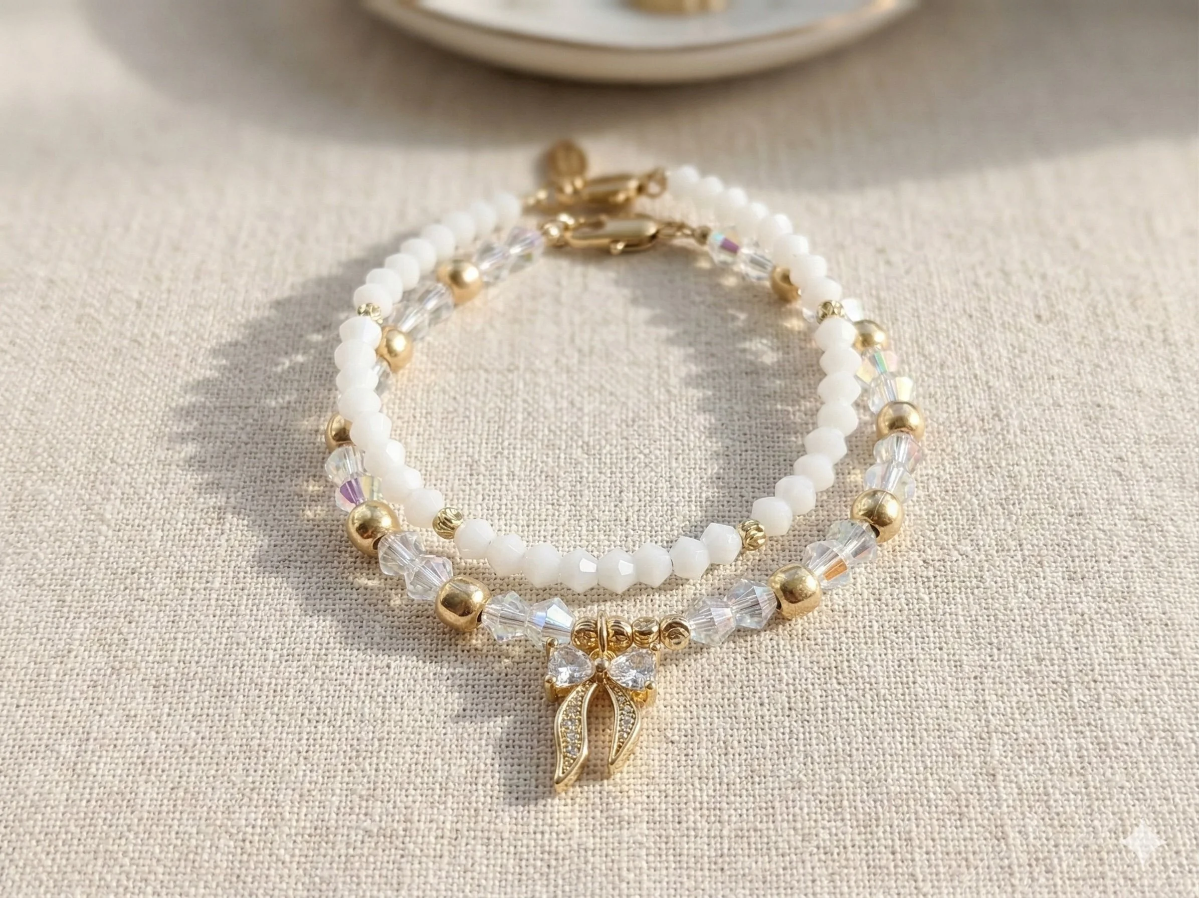 Gold and white crystal heart and bow bracelet set featuring stacked feminine jewelry charms.