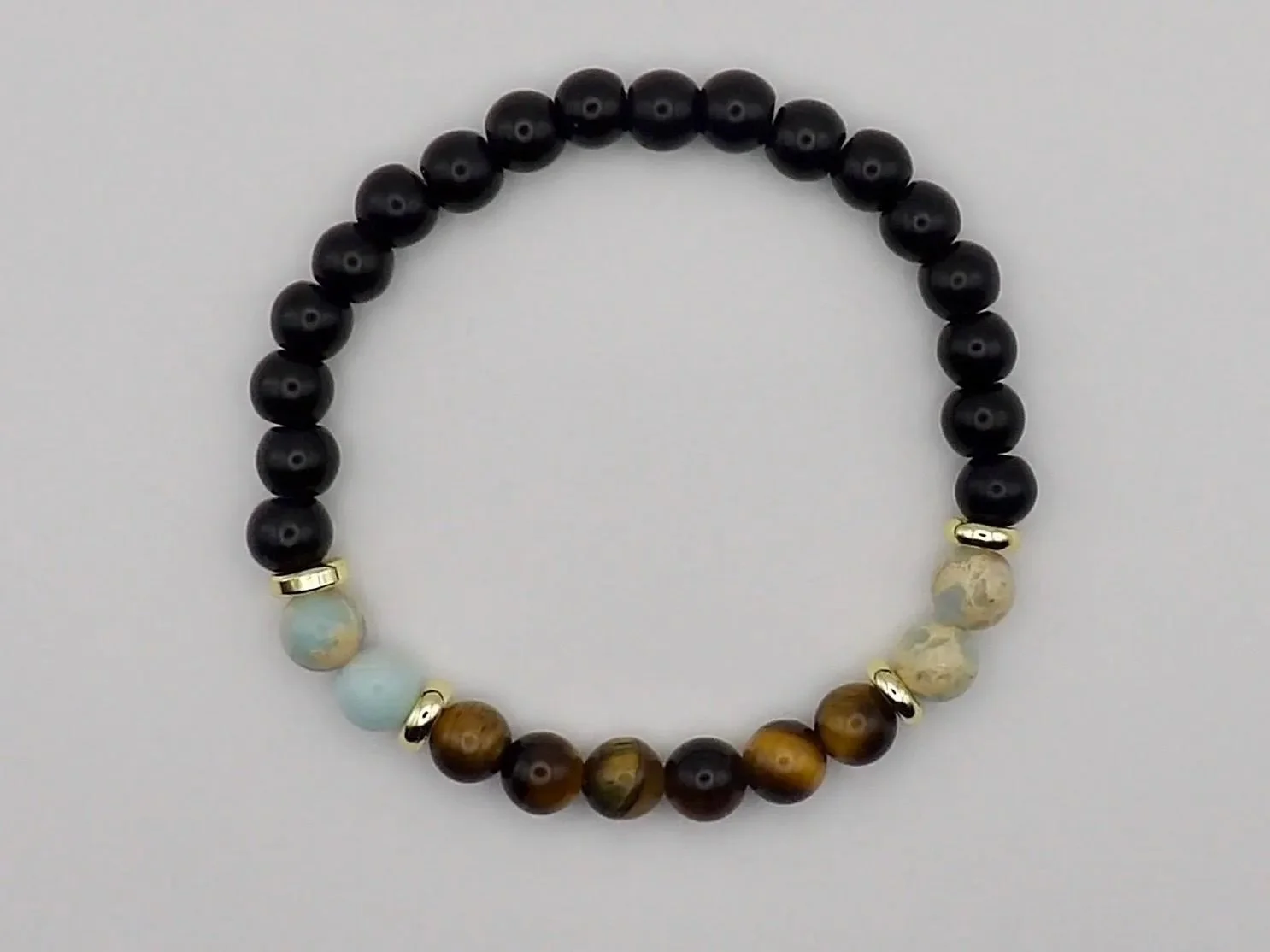 close-up of the sophisticated earthy bracelet highlighting the chatoyancy of the tiger’s eye and the smooth, matte finish of the blue african opal.