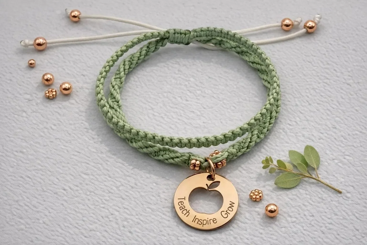 the heart-led educator bracelet featuring a premium rose gold charm engraved with "teach inspire grow" on a double-strand macramé band.