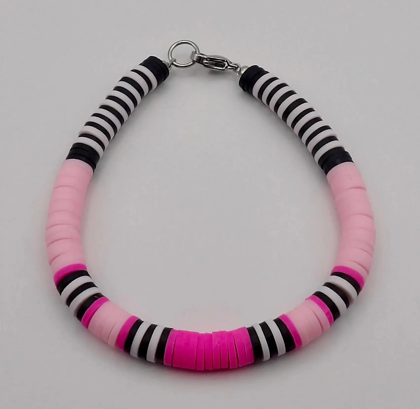 a high-contrast, modern heishi stack showing the rhythmic transition from vibrant pink to deep black beads.