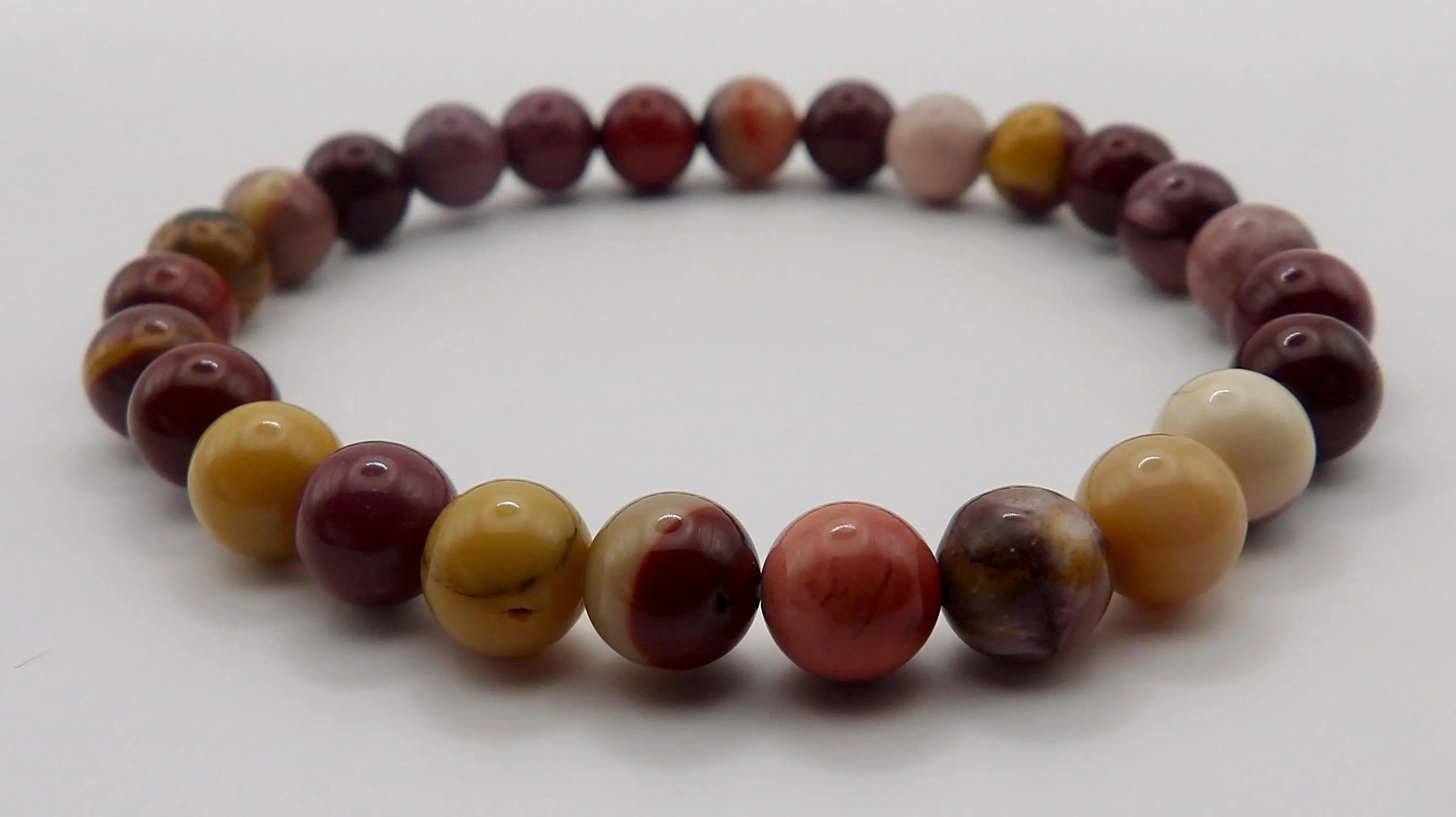 close-up of the earthy wanderer jewelry highlighting the smooth, polished finish of the mookaite jasper beads.
