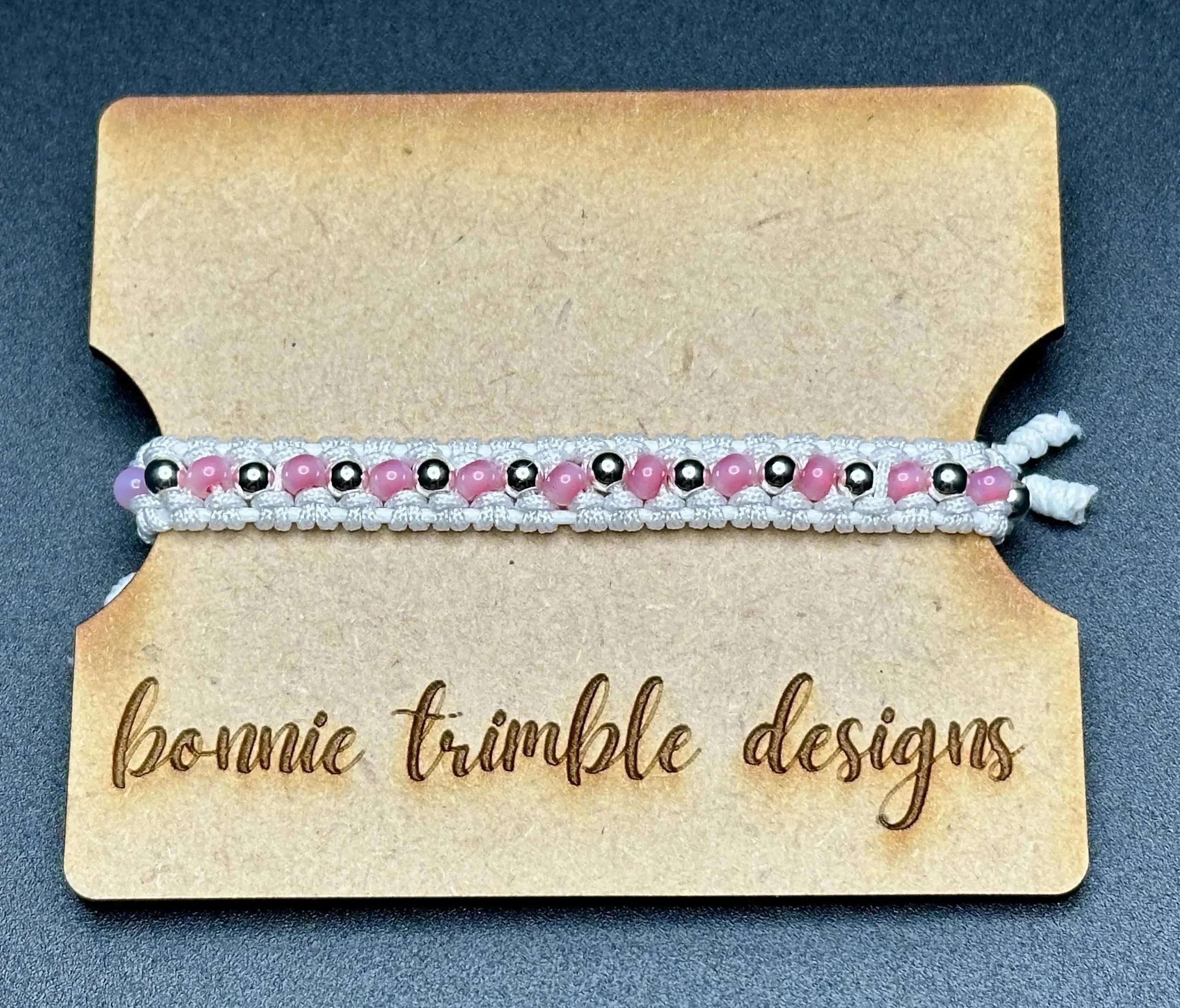 an airy and romantic hand-woven anchor bracelet designed with a signature white macramé pattern and sterling silver beads.
