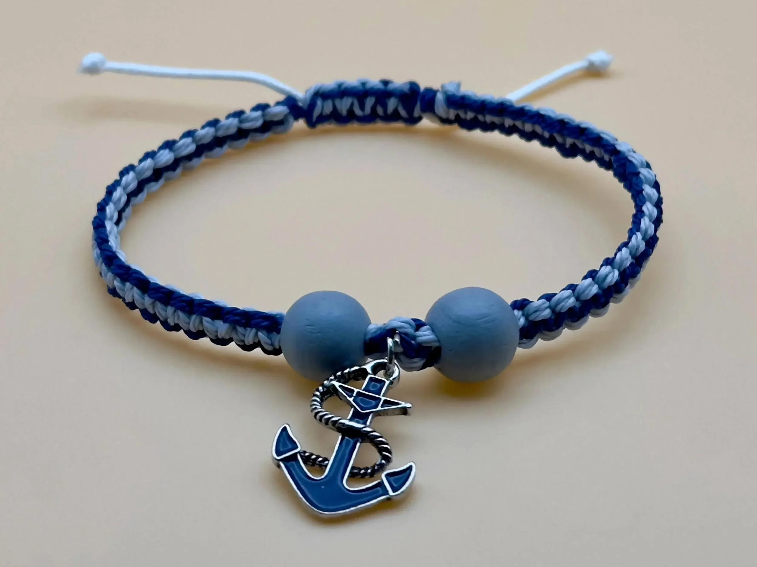 close-up of the coastal adventurer bracelet showcasing the blue anchor detail and natural wood bead spacers.