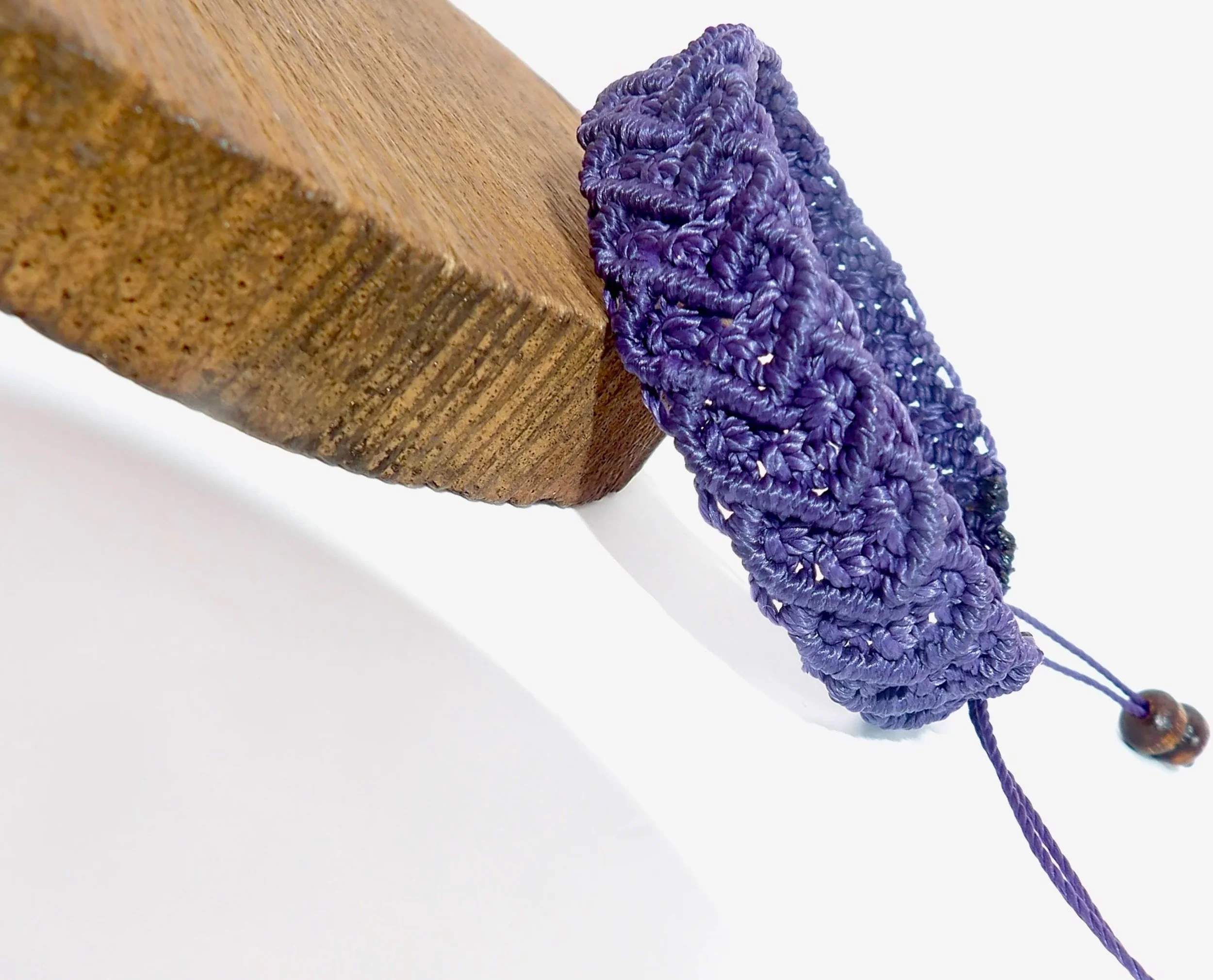 handcrafted macramé cuff bracelet featuring a broad woven surface and a symmetrical heart pattern throughout.