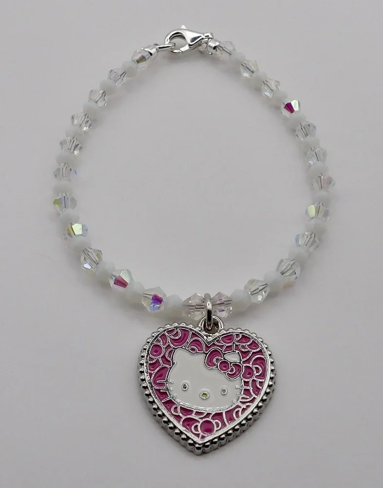 close-up detail of the sterling silver and pink mosaic hello kitty heart charm, set against sparkling ab crystal beads.