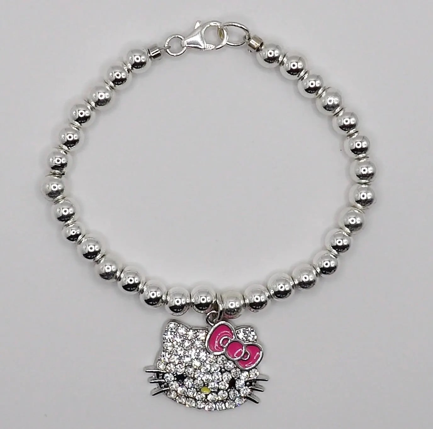 an elegant, hypoallergenic sterling silver anchor bracelet featuring a pink hello kitty mosaic charm for a playful luxury look.
