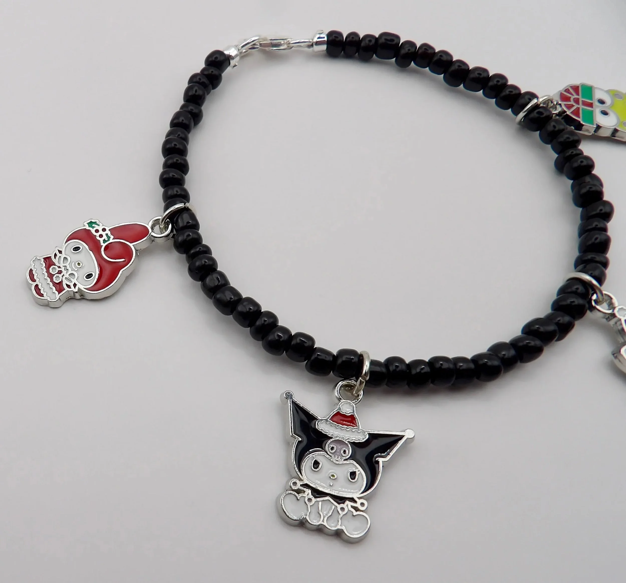 handcrafted .925 sterling silver holiday jewelry with detailed hello kitty christmas icons and a sophisticated black and silver color palette.