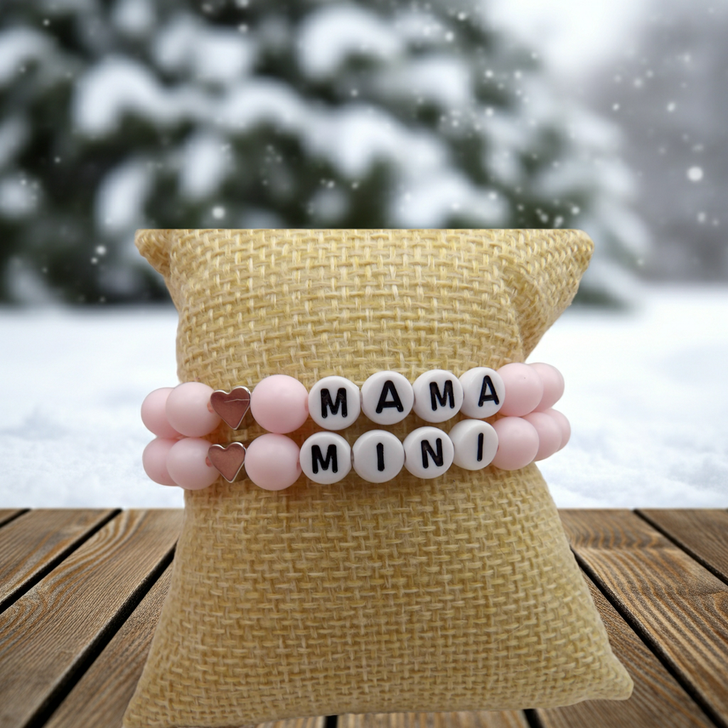 close-up detail of the "mama" letter beads and sterling silver heart charm on the powder pink stretch bracelet for moms.