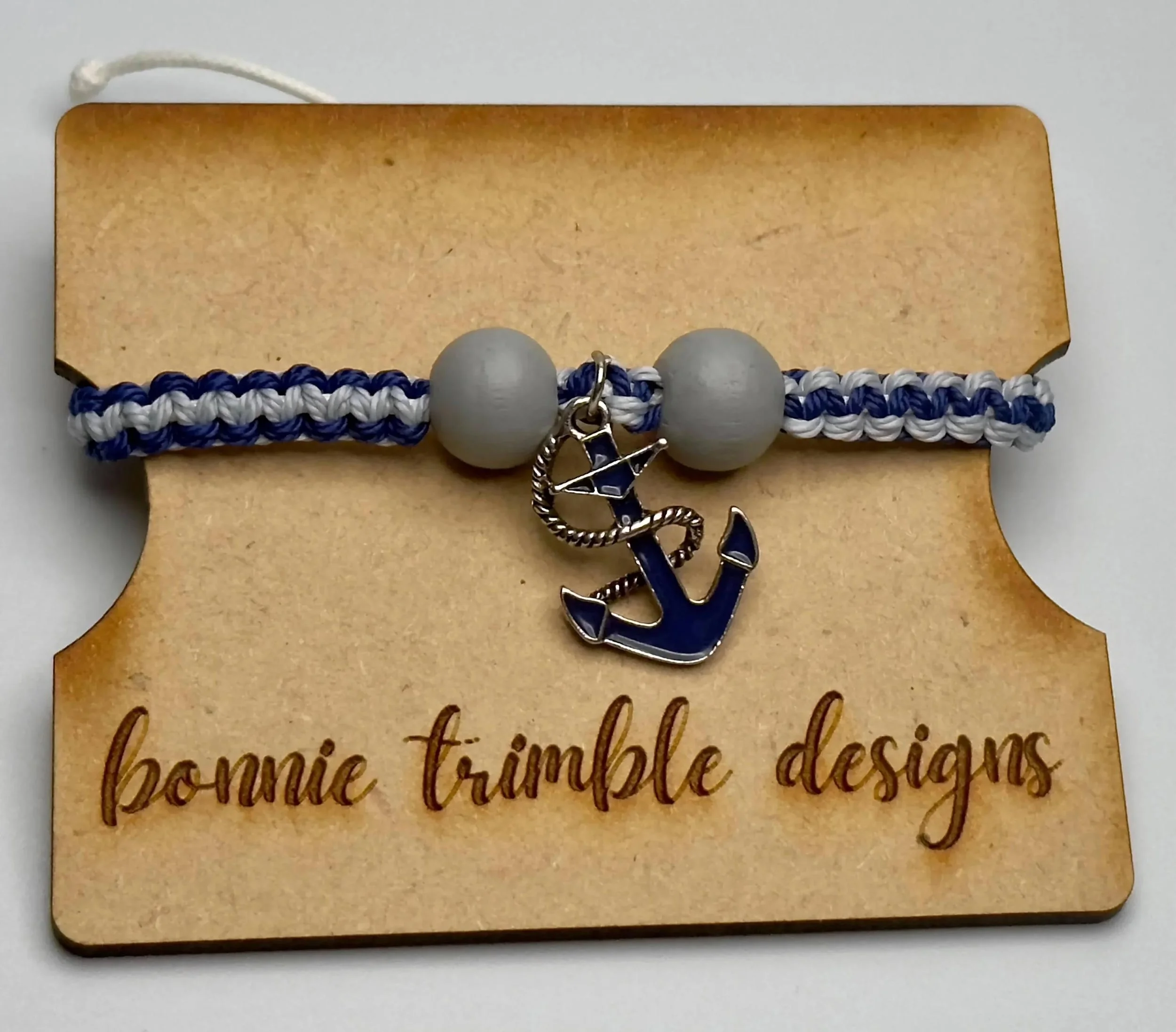 unisex nautical bracelet featuring a blue anchor charm and a durable two-tone macramé band for an active lifestyle.