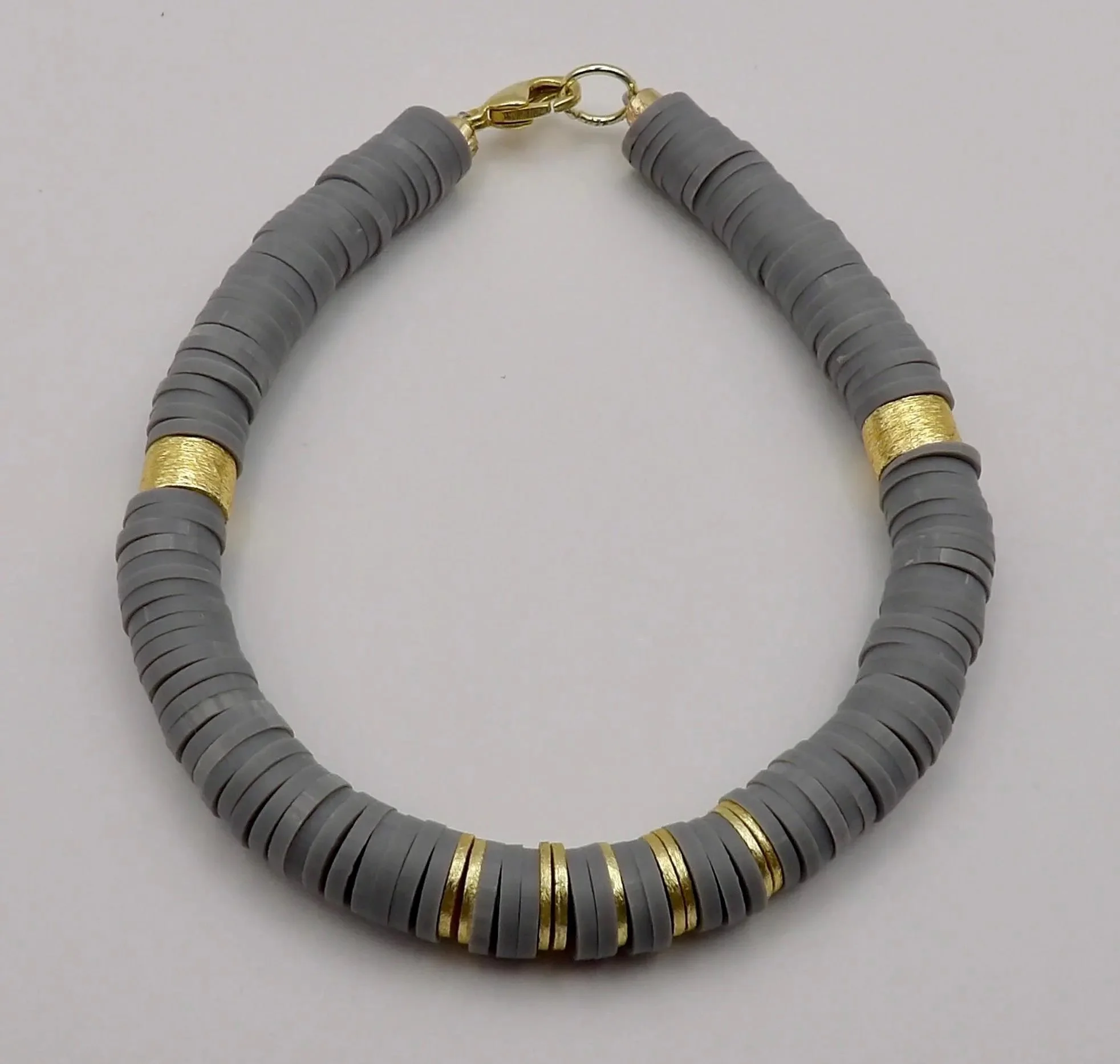 close-up of the modern architect bracelet highlighting the subtle texture of the matte gray beads and the warm gold-toned finish.