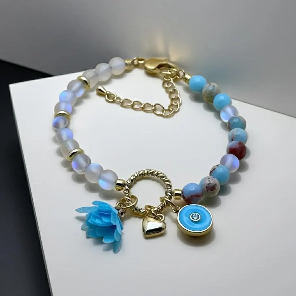 close-up of the whimsical dreamer bracelet highlighting the shimmering gold-filled hardware and the deep blue tones of the opal cluster.