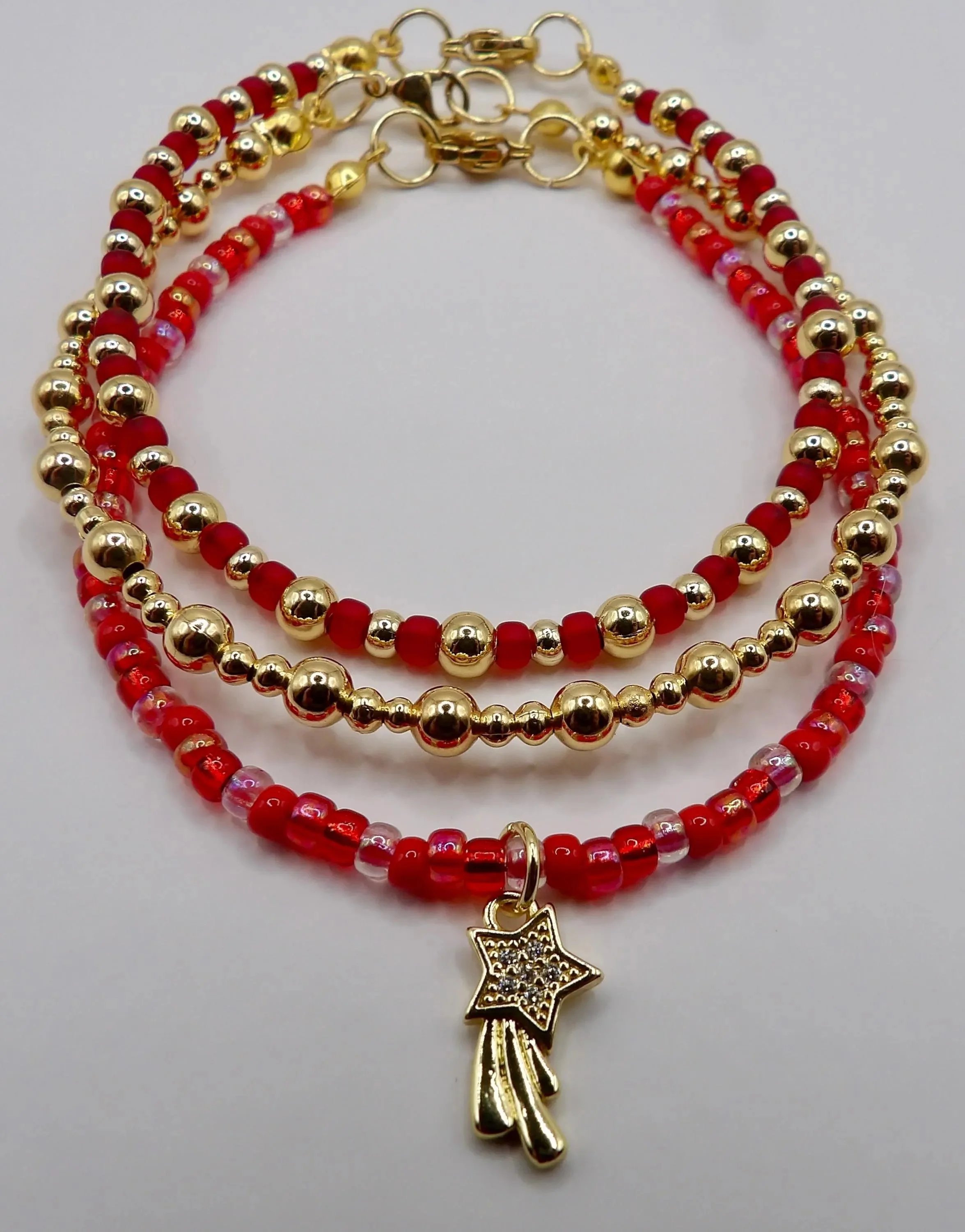 detailed view of the precision stone-setting on the shooting star charm alongside the flawless polish of the 18k gold beads.