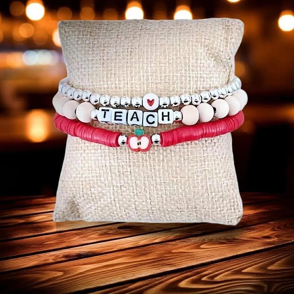 sterling silver teacher appreciation jewelry set with a vibrant red enamel apple charm and "teach" letter beads for a meaningful gift.