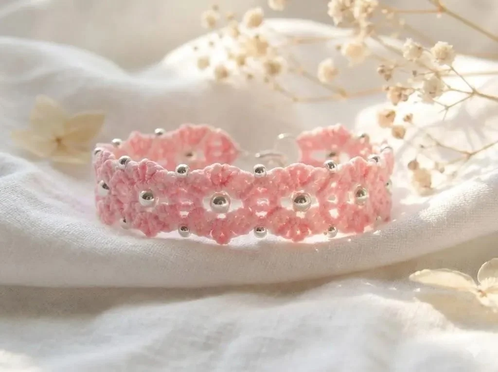 close-up of the woven bloom bracelet highlighting the precise micro-macramé knots and the shimmer of the sterling silver beads.