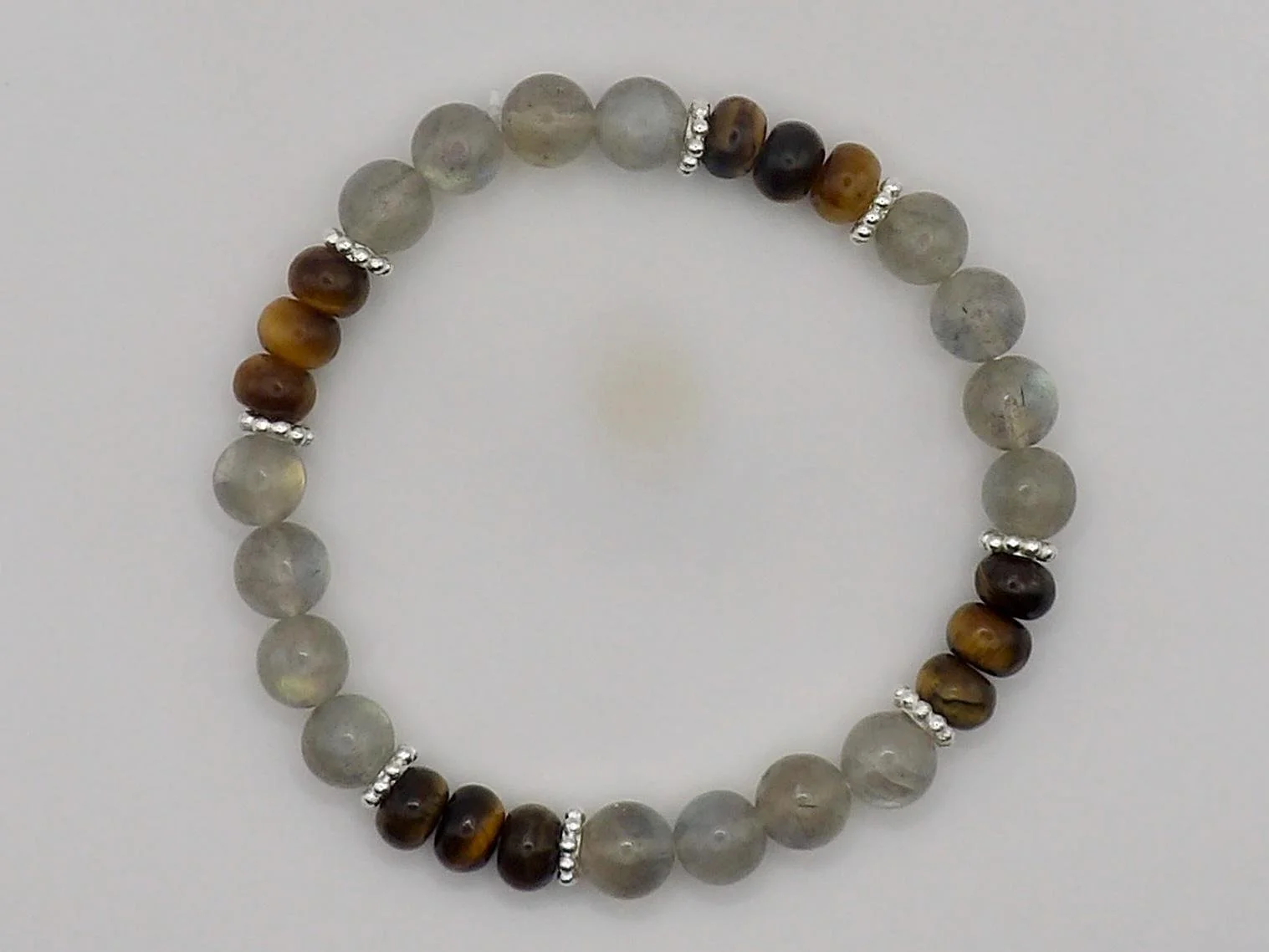 the intuitive wanderer bracelet styled for a professional wardrobe, demonstrating how the hidden blue flash of the labradorite catches natural office light.
