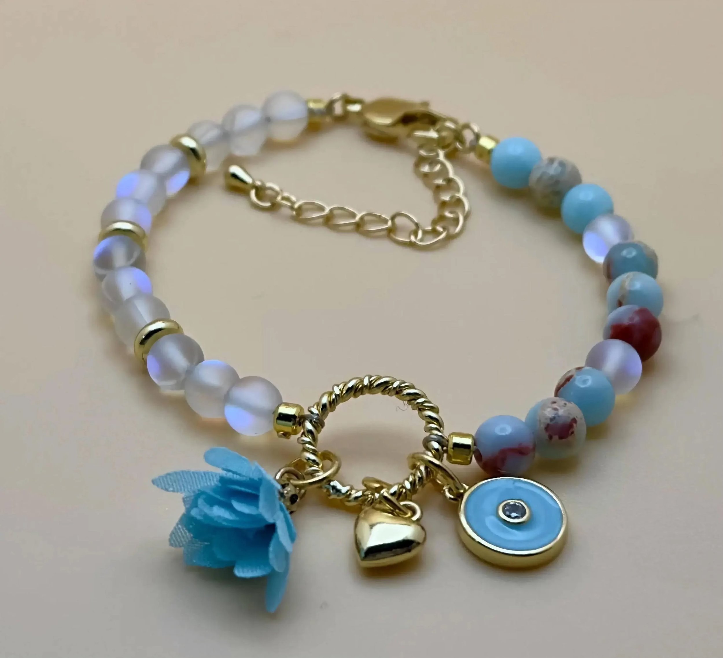 a whimsical and sophisticated gold-filled anchor bracelet designed with a signature blue gemstone charm cluster.