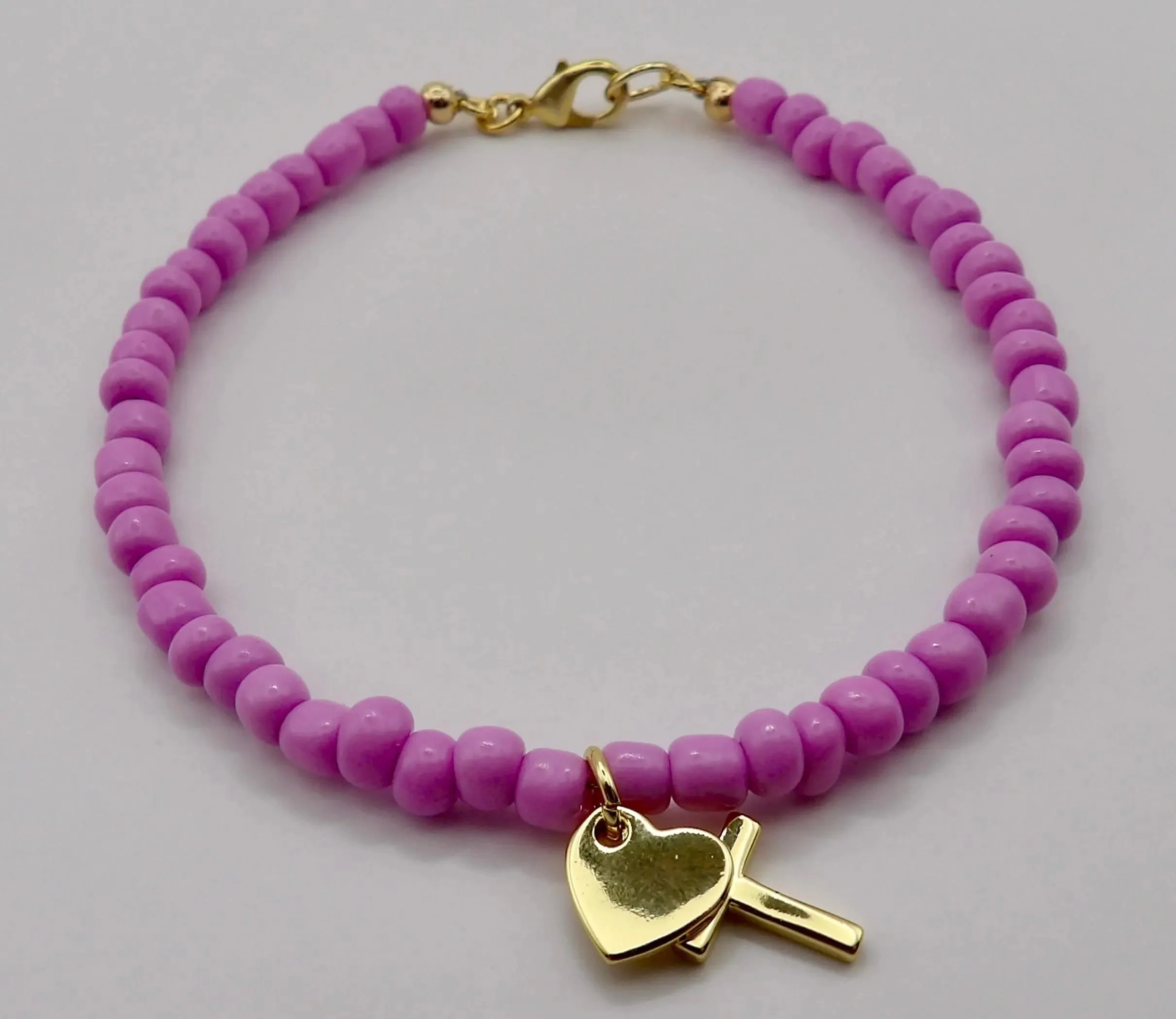 personalized faith bracelet featuring a small gold plated cross and heart on a durable strand of seed beads.