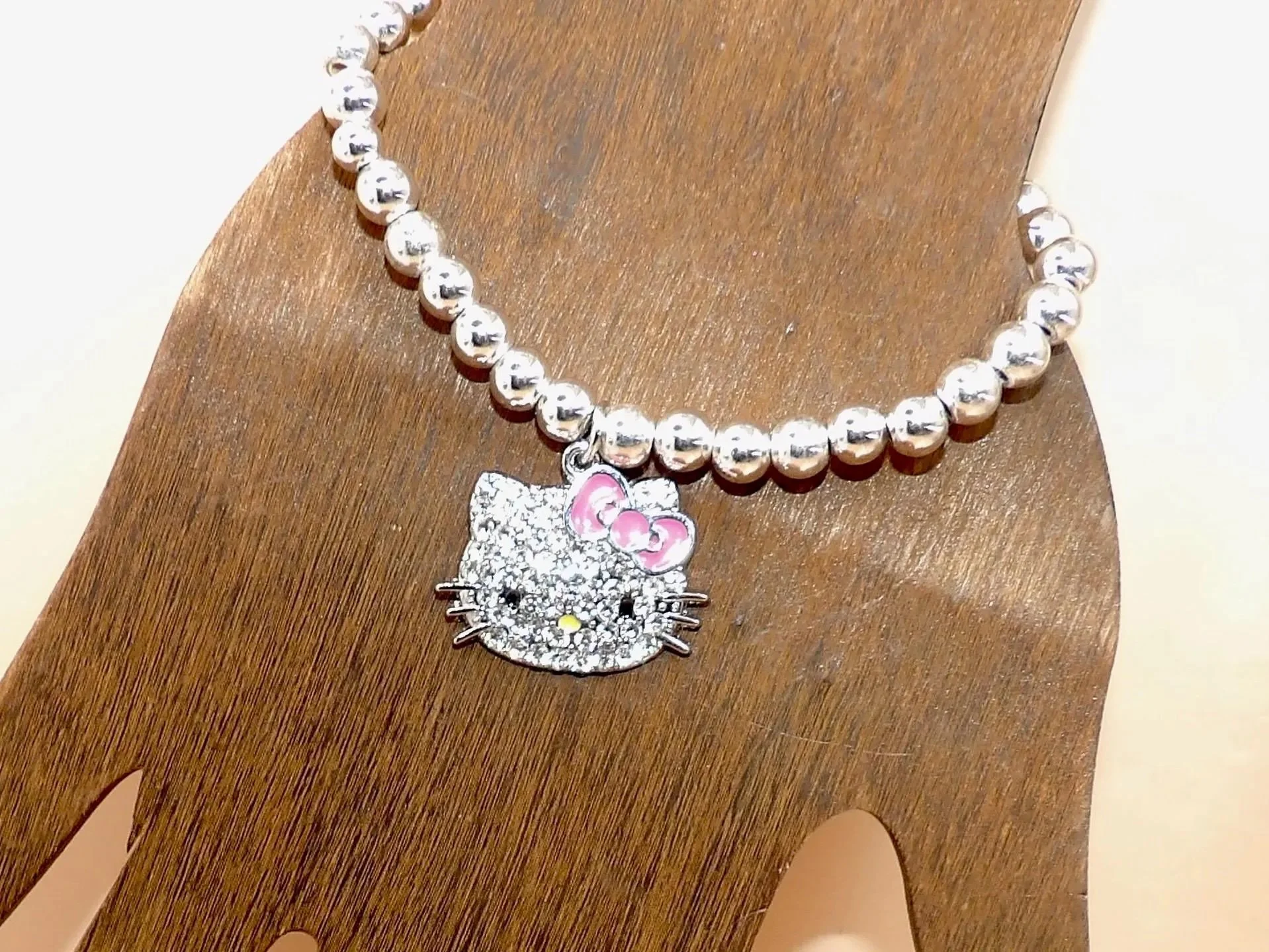 the sparkle enthusiast bracelet styled for a "coquette-luxe" wardrobe, emphasizing its fine silver shine and pastel pink detailing.