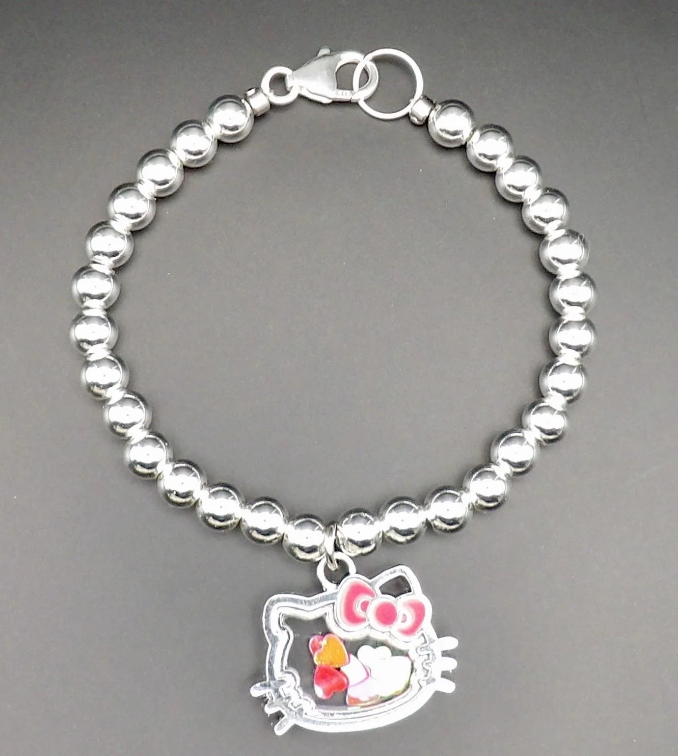 the hello kitty shaker bracelet styled for a "kidcore-chic" aesthetic, emphasizing its premium silver materials and playful charm.