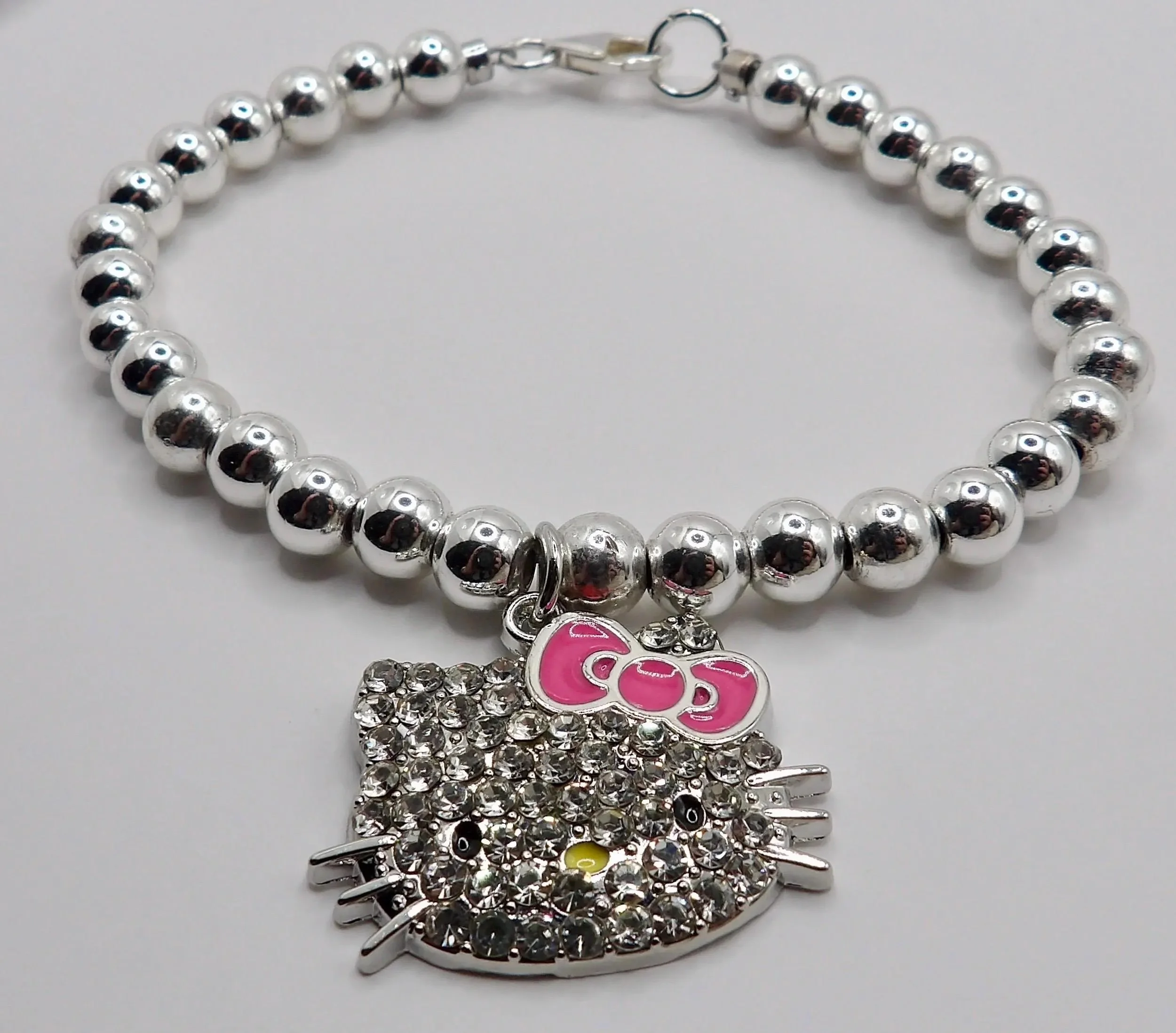 detailed view of the sterling silver hallmark alongside the intricate geometric tile pattern of the pink hello kitty mosaic charm.