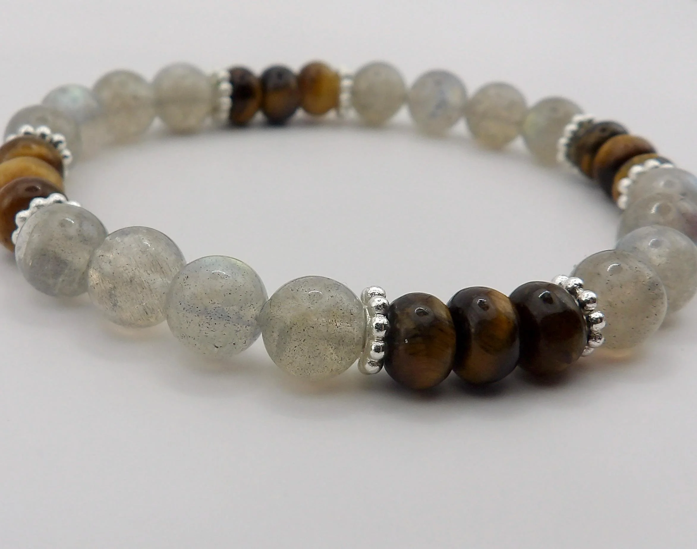 detailed macro shot of the natural mineral bands in the golden tiger's eye contrasting beautifully with the icy blue iridescence of the labradorite.