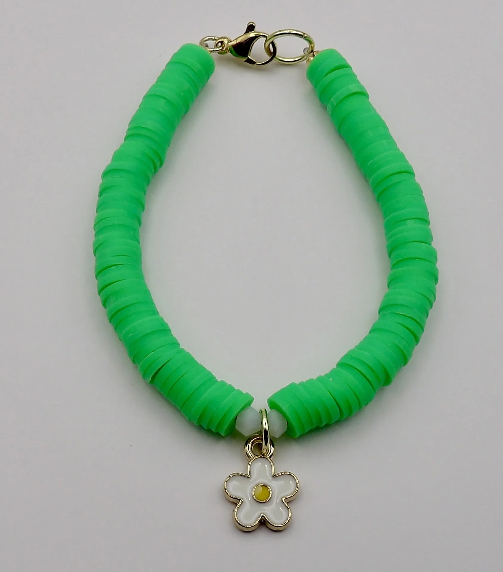 view of the secure solid 14k gold lobster clasp and findings on the handmade green heishi bead bracelet.