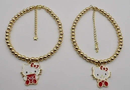 person wearing the 2-piece 18k solid gold hello kitty charm bracelet set, showing the luxurious stack.