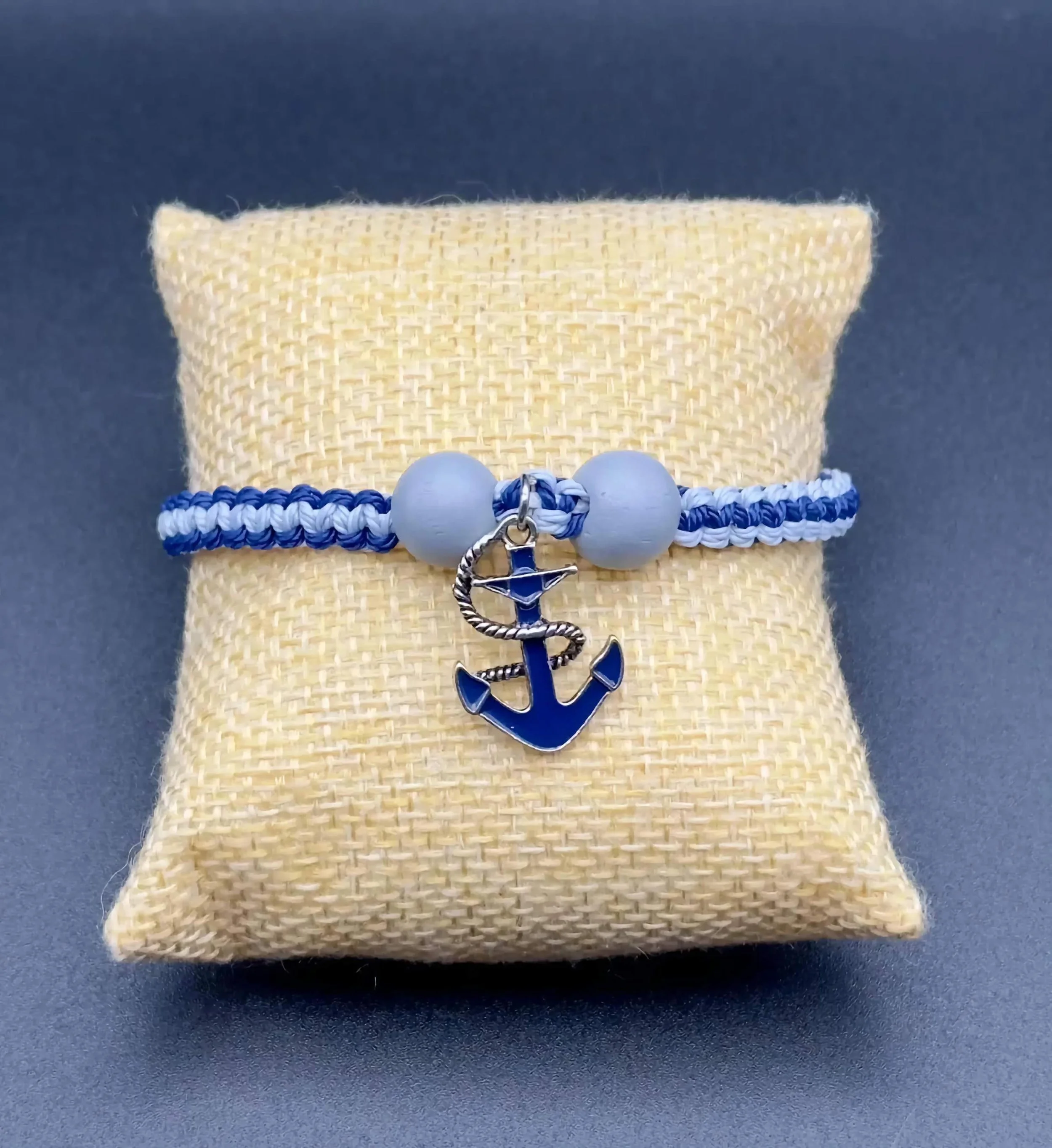 handmade coastal adventurer stack with a blue anchor and earthy wood beads on a weathered wood background.