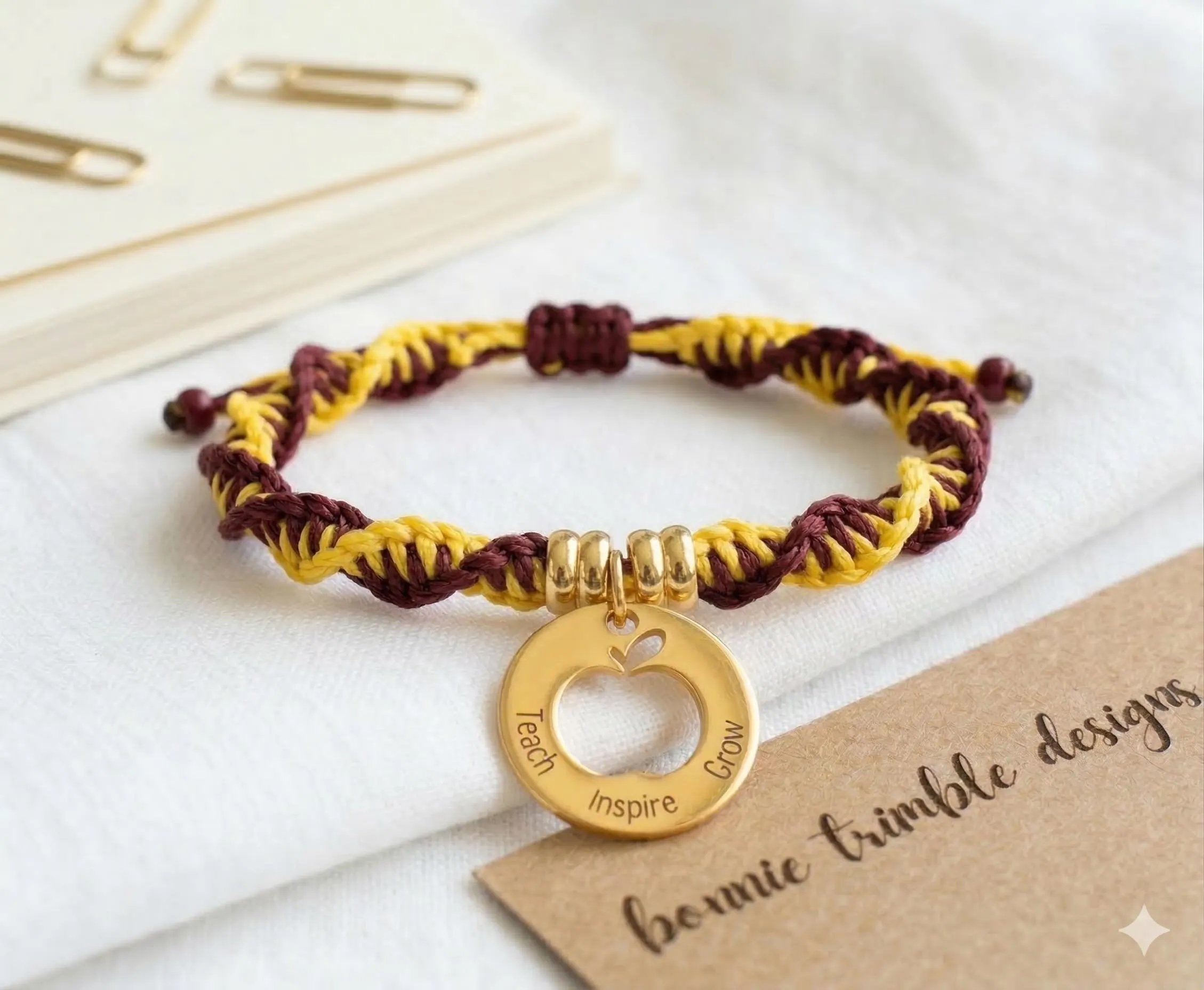 a high-end teacher appreciation gift showing the shimmering gold-plated engraved charm and a sleek adjustable sliding knot.