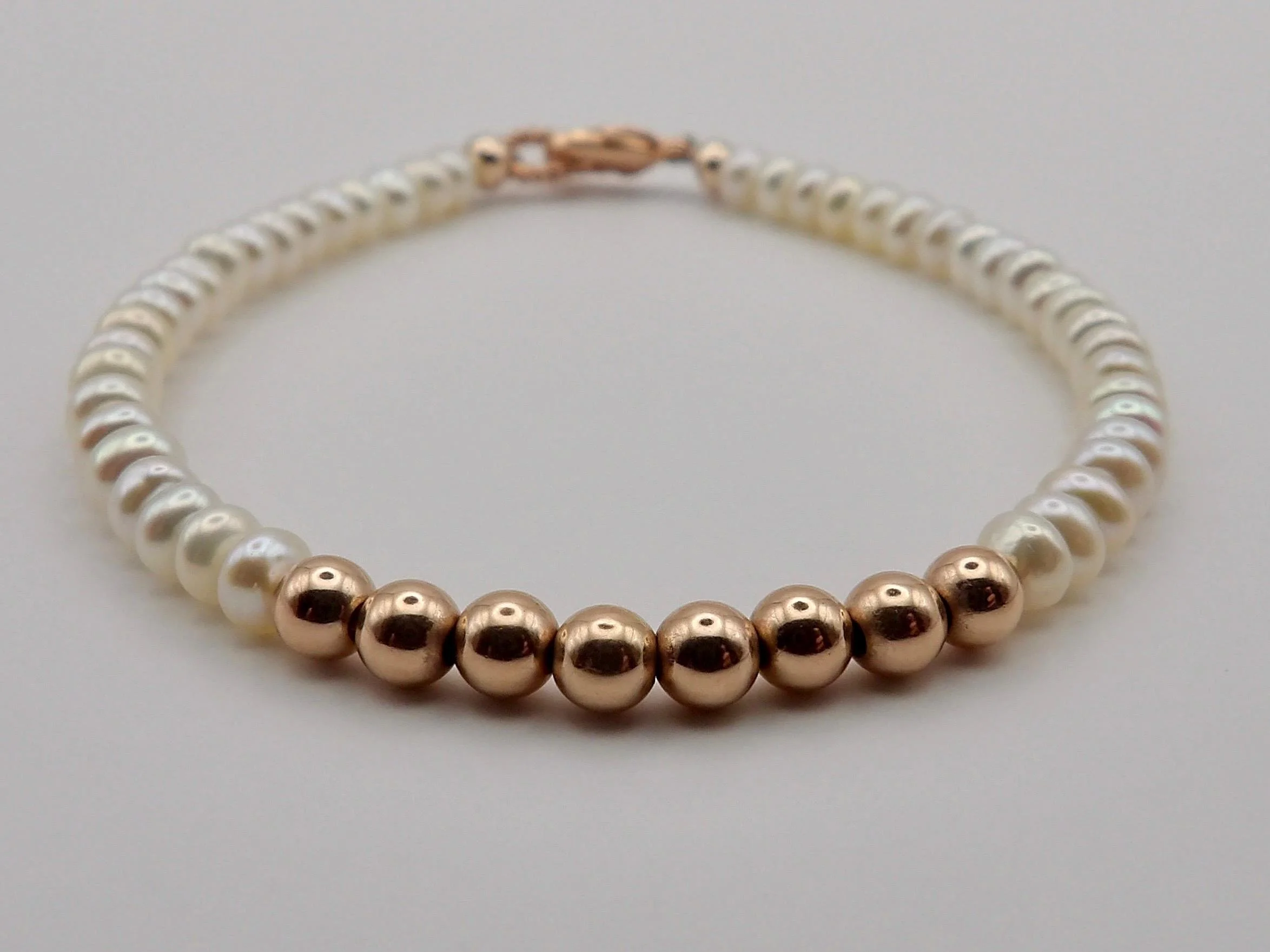 a premium take on the pearl strand, featuring 14k rose gold filled beads and natural freshwater pearls in a 4mm size.