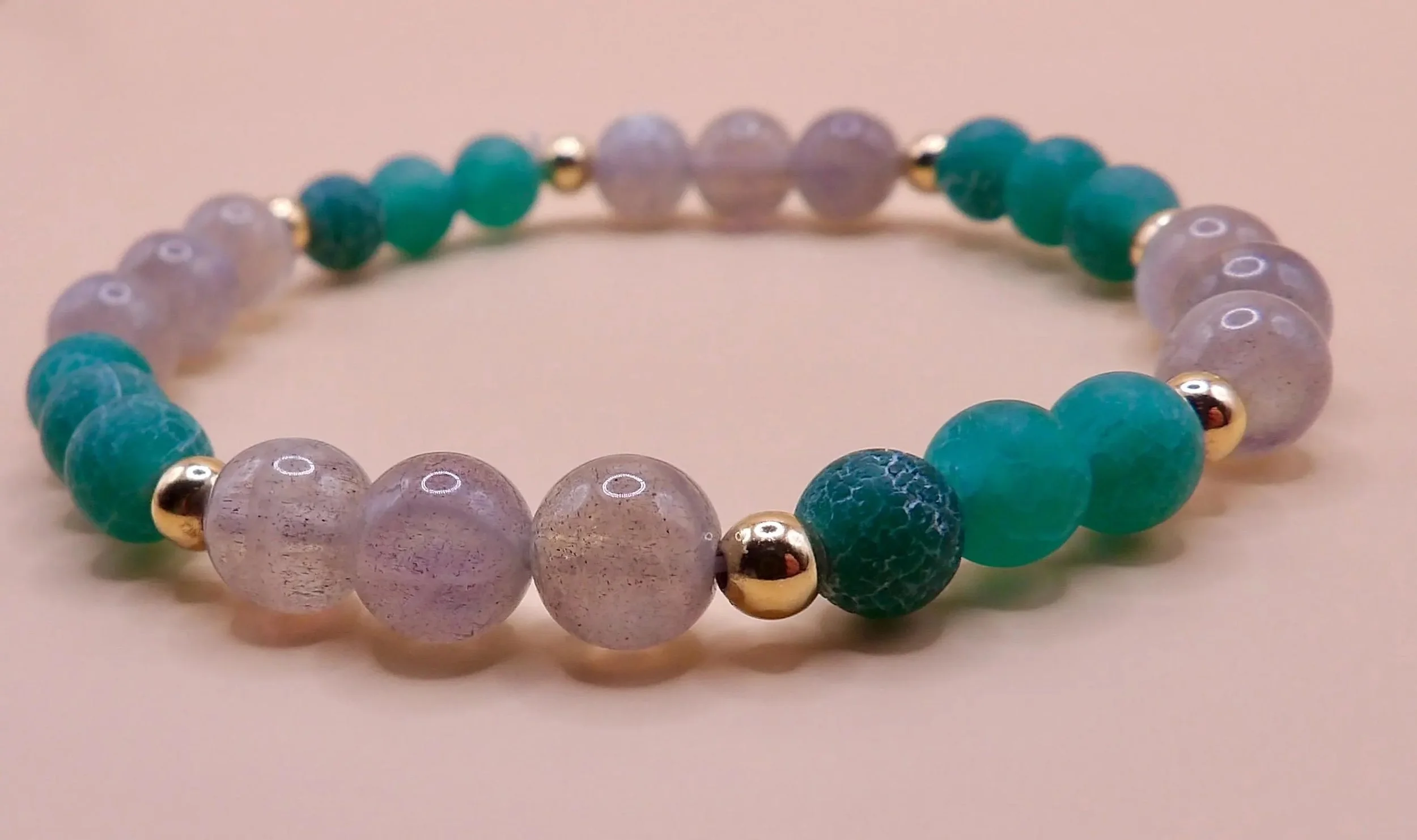 detailed view of the matte finish on the green agate beads contrasted with the polished glow of the gold-filled spacers.