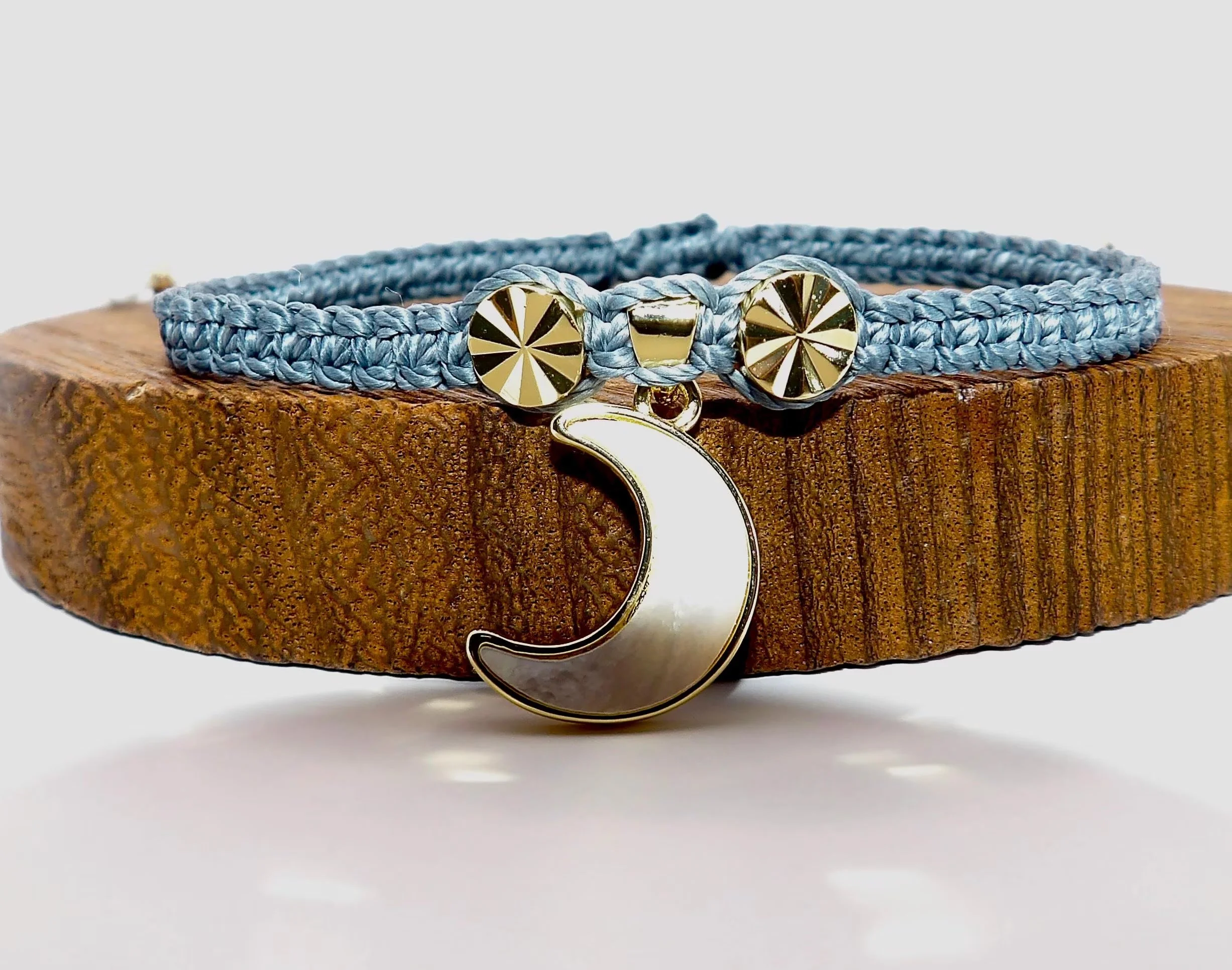 Handcrafted charcoal gray micro-macramé bracelet featuring durable waterproof cord and polished gold starburst accents.
