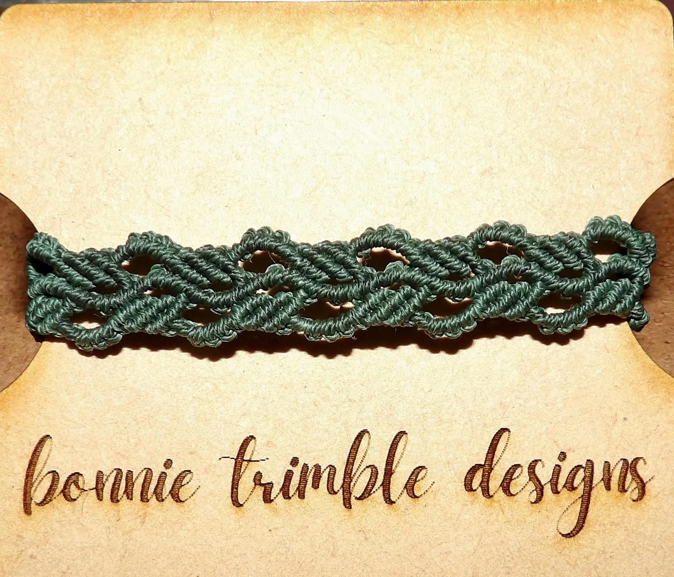 high-resolution product shot of the botanical weave bracelet on a natural wood background to emphasize its organic roots.