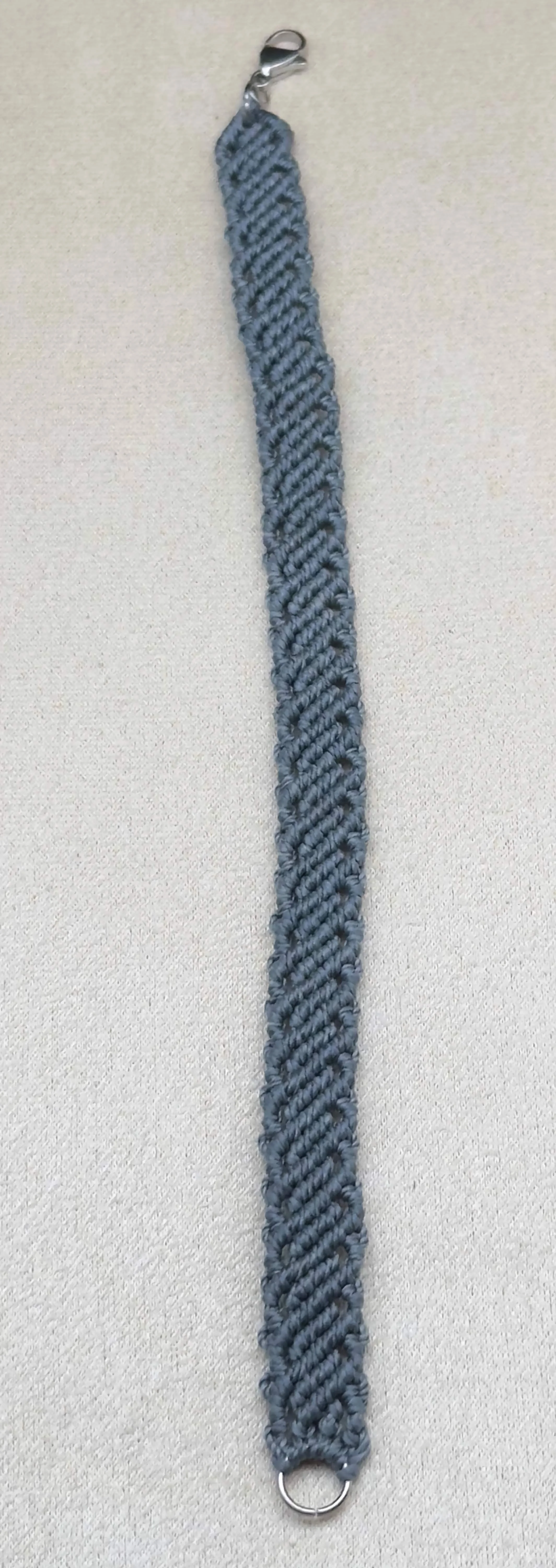 A unique micro macrame bracelet for men, styled with a leather watch and a rugged notebook.