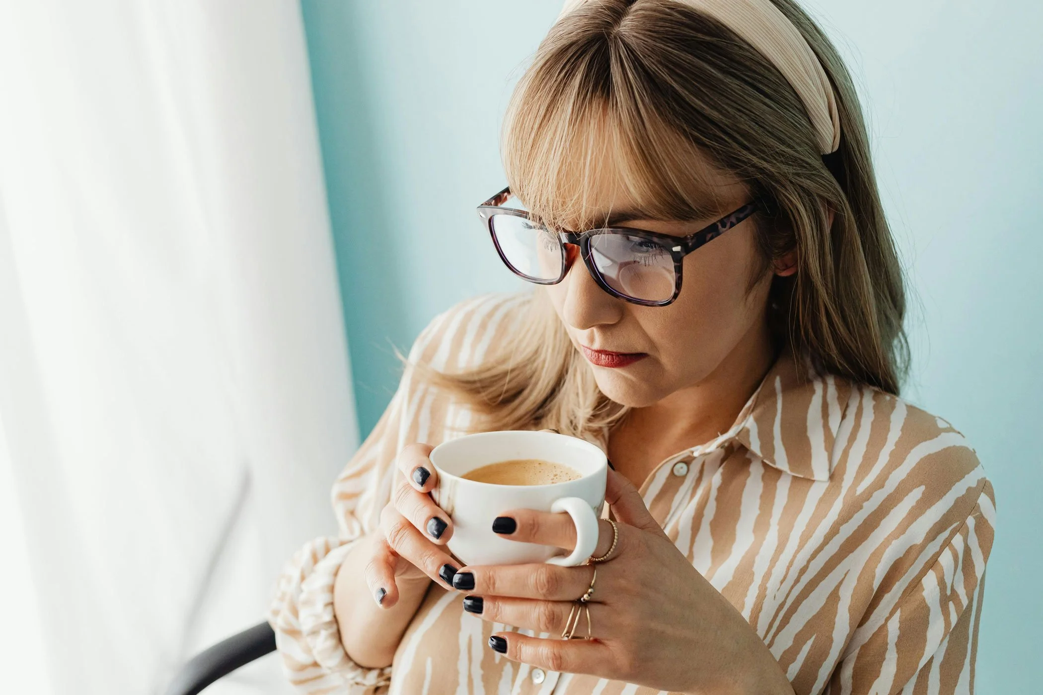 middle aged woman having difficulty concentrating while drinking coffee