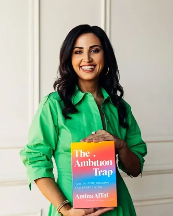 Amina AlTai holding a copy of her book The Ambition Trap