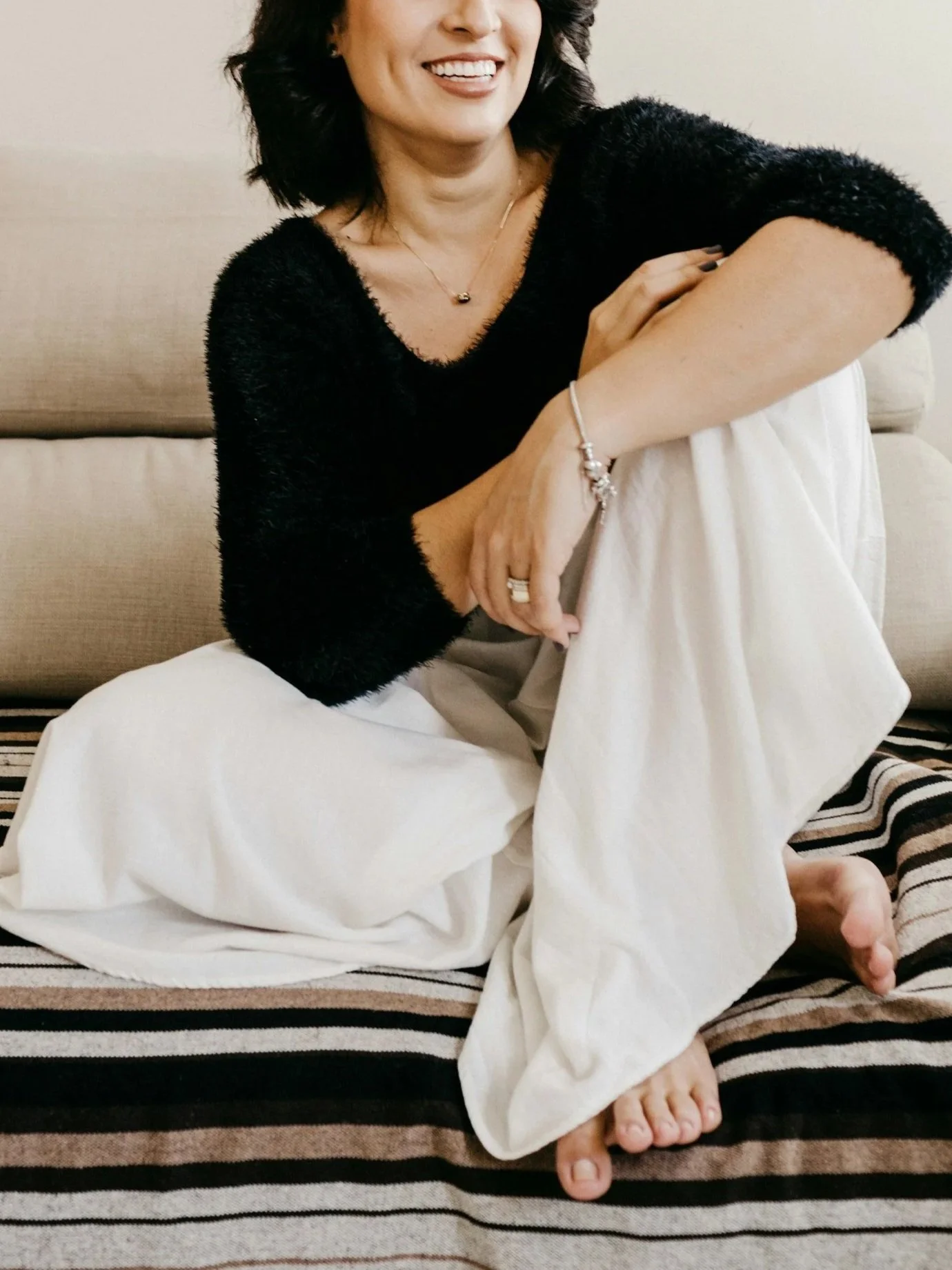 Woman in her late 30s sitting on sofa