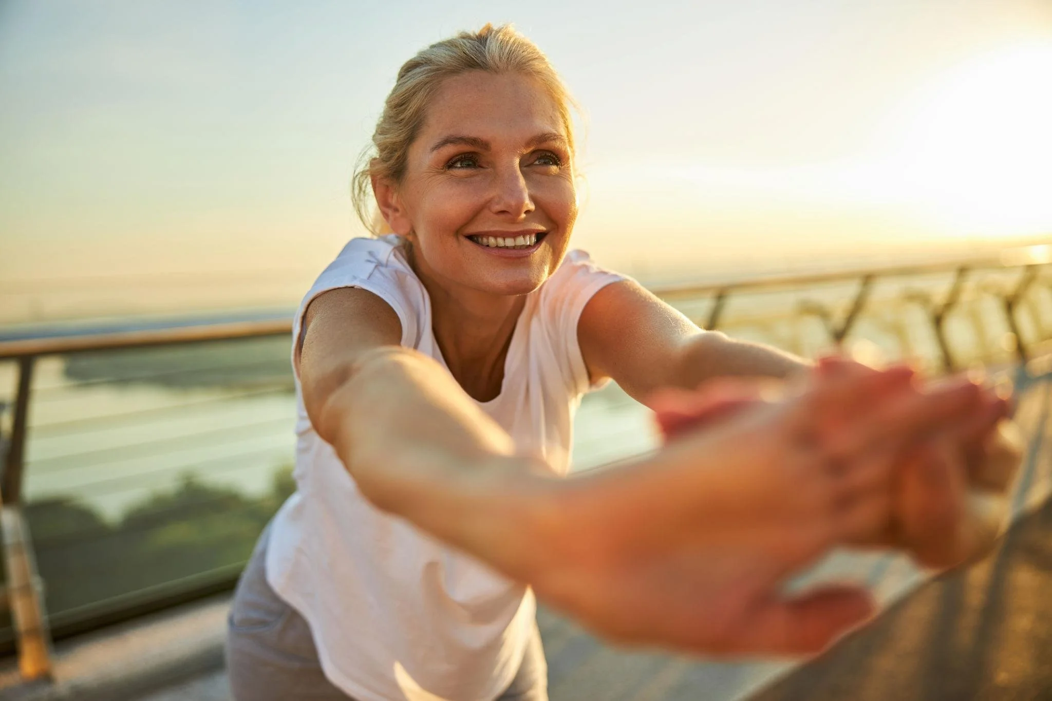 Woman stretching to relieve menopause-related joint pain before exercise.
