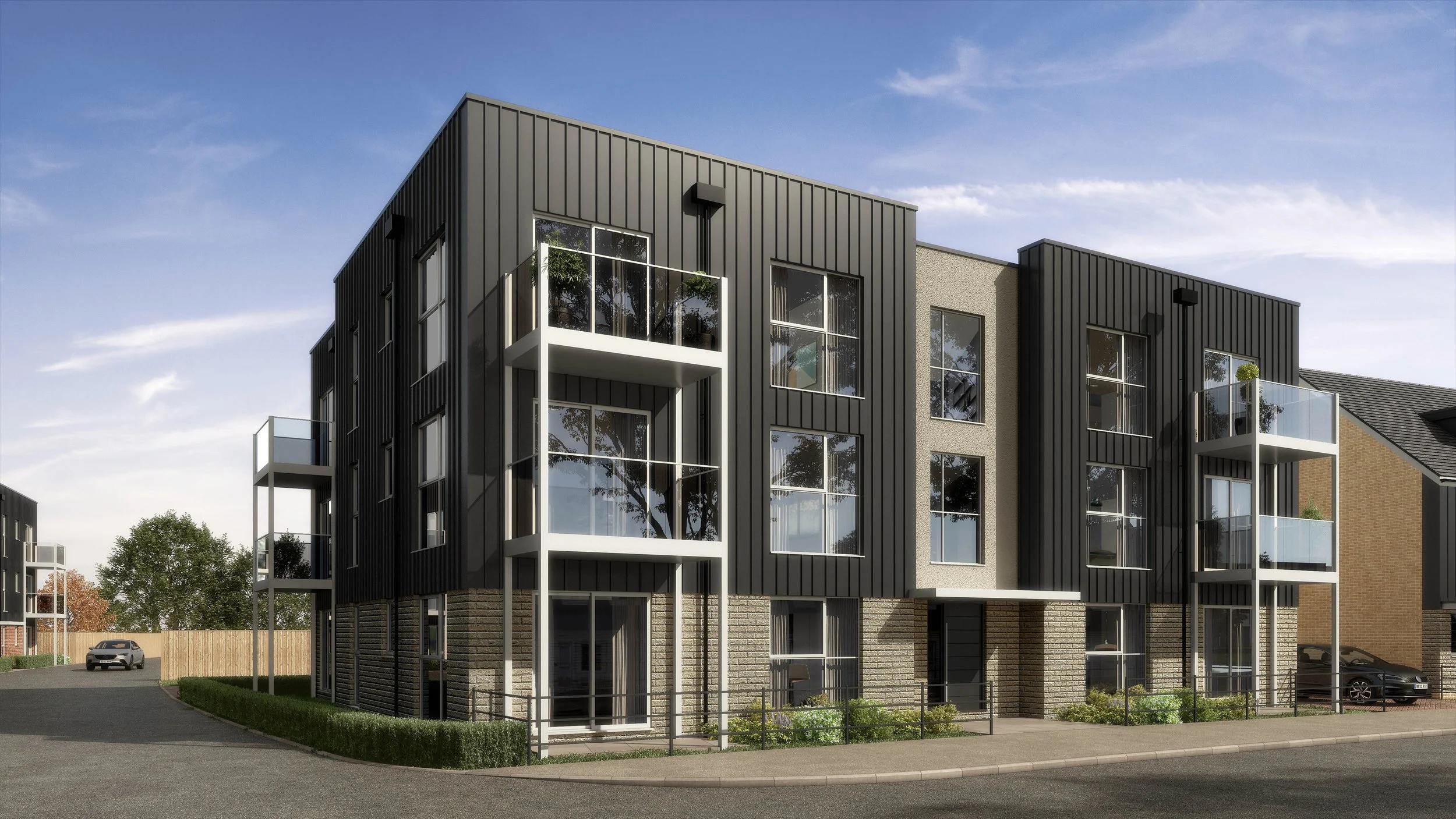 Modern multi-story residential building with dark metal siding, large glass windows, and small balconies, situated along a paved street with greenery and parked cars.