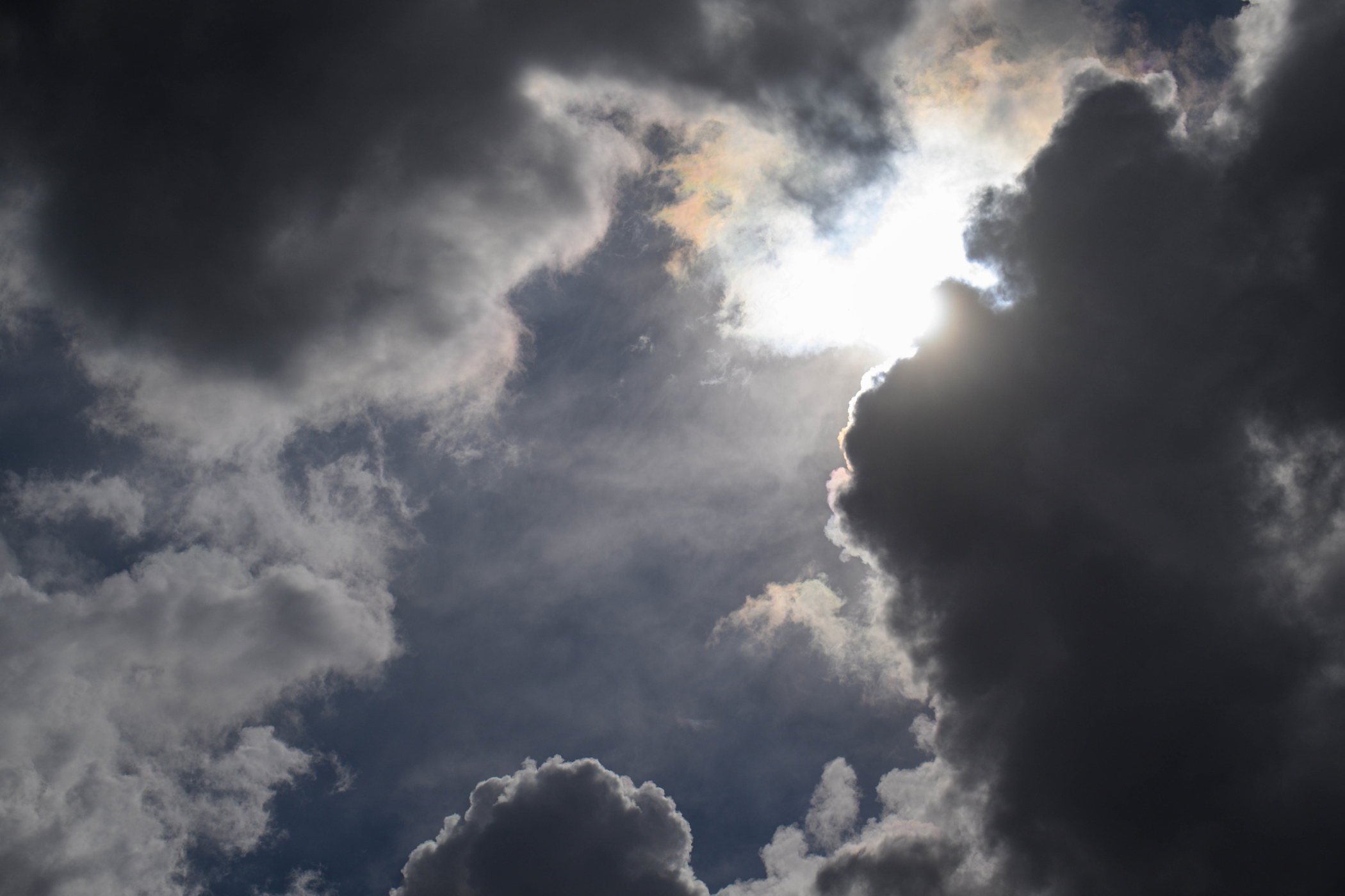 Sunlight breaking through dark storm clouds in a dramatic sky